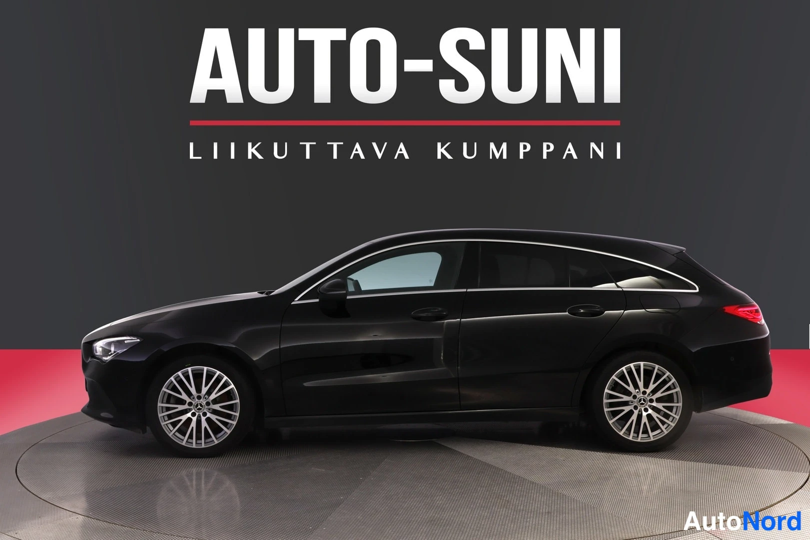 Sivulta: Mustan Mercedes-Benz CLA Shooting Braken sivuprofiili studioalbumen pyörivällä alustalla, AUTO-SUNI-logotausta.