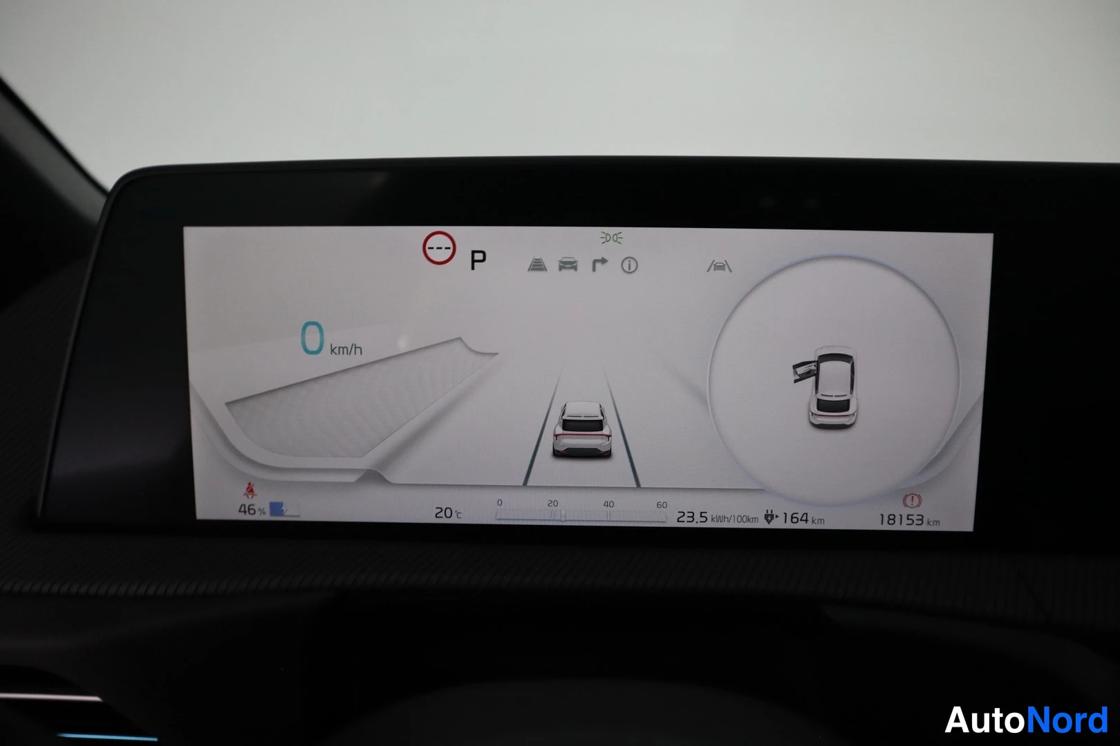 Muu: Auton kojelaudan infotainment-näyttö: nopeus 0 km/h, vaihde P, akun varaustaso 46 %, jäännösajomäärä 164 km, kulutus 23,5 kWh/100km ja kokonaisajomäärä 18153 km
