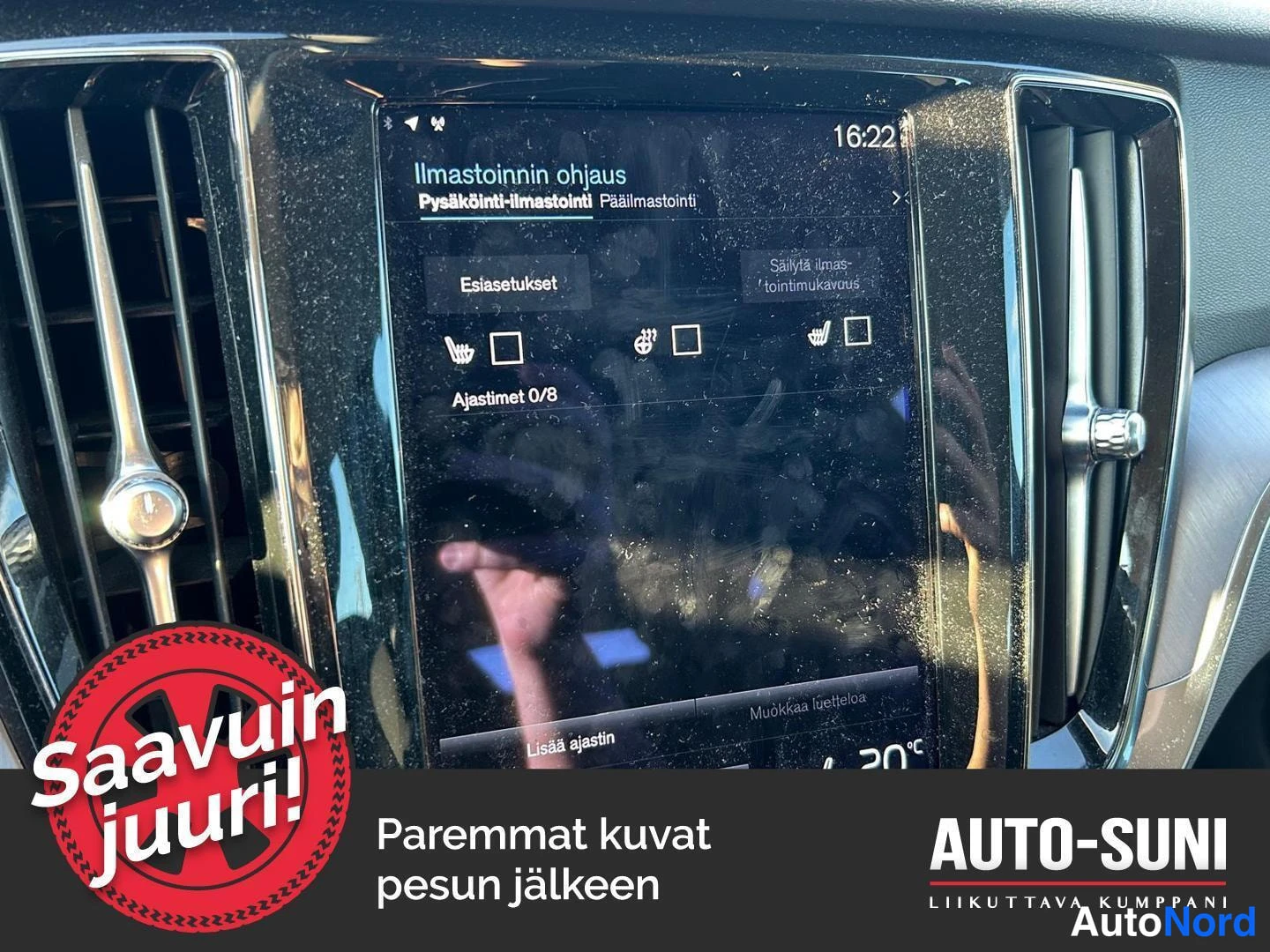 Yksityiskohta: kojelaudan suuren pystynäytön lähikuva näyttäen ilmastoinnin ohjausruutua (Ilmastoinnin ohjaus, Esiasetukset, Ajastimet 0/8) ja molemmin puolin ilmastointiritil