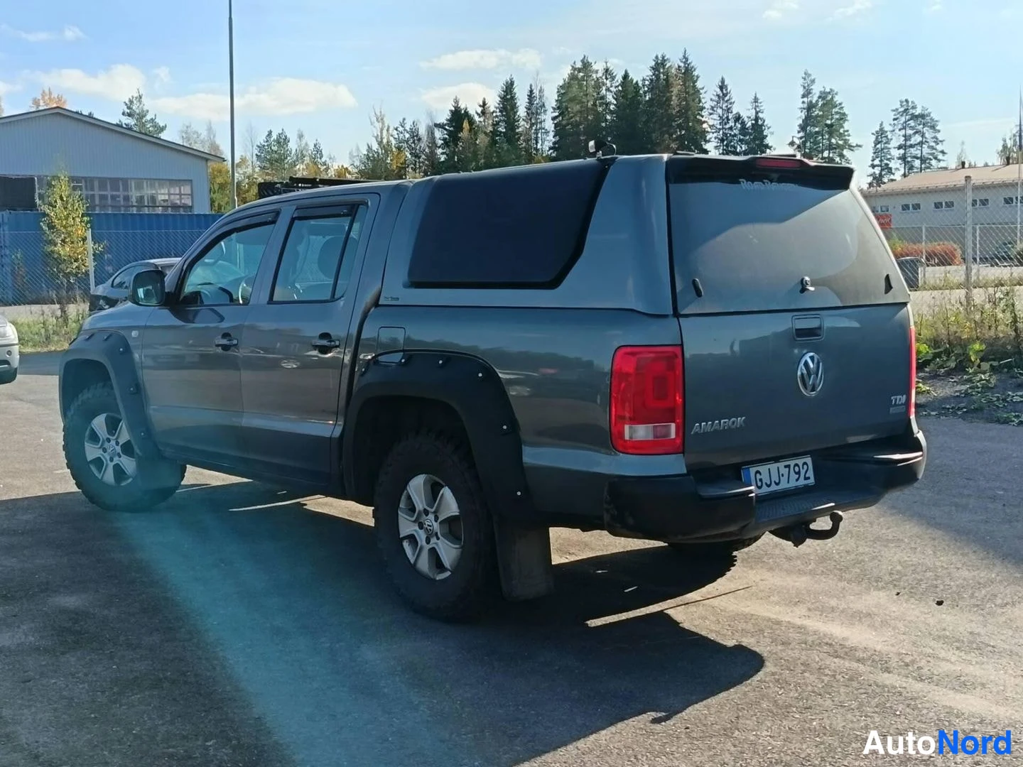 Takaviisto: Harmaa Volkswagen Amarok -lisävarustekuormatila, takakolmasosan näkymä rekisterillä.