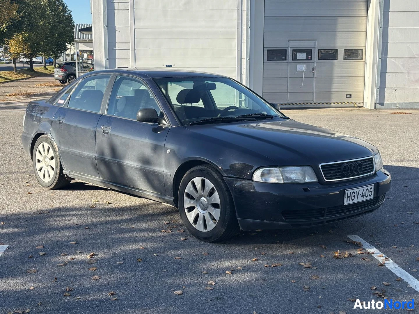 Etuviisto, nokka oikealle: Mustan sininen Audi A4 -sedan kulmasta etupuolelta oikealta kuvattuna, rekisteritunnus.