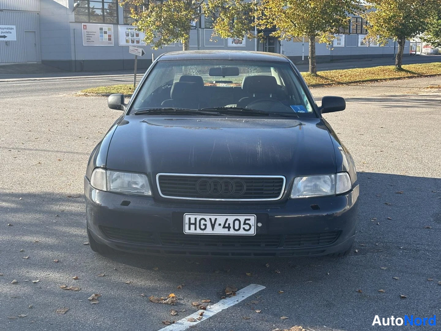 Edestä: Etupuolelta suoraan kuvattu tummansininen Audi A4, rekisteritunnus.