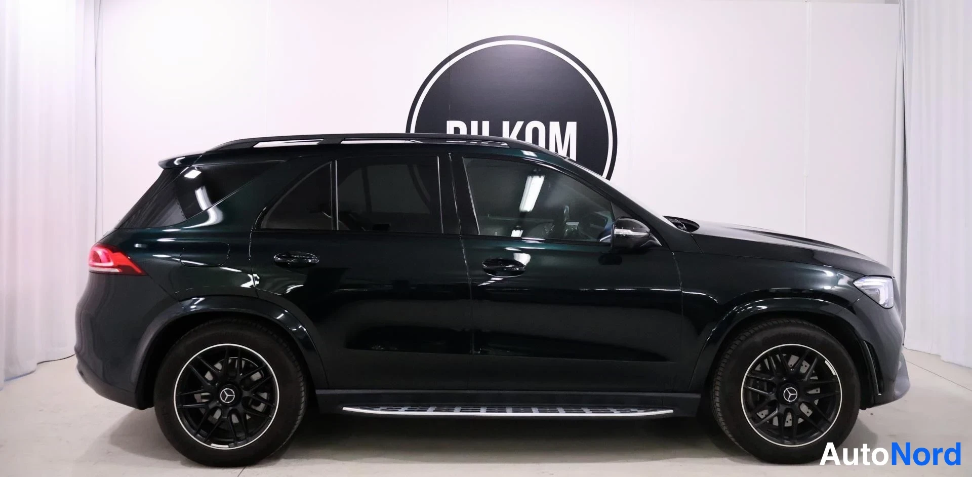 Sivulta: Mercedes-Benz GLE:n vasen kylki sivusuunnasta; näkyvissä tumma metalliväri, mustat kevytmetallivanteet, kattokaiteet ja kromiset asta-lauteet.