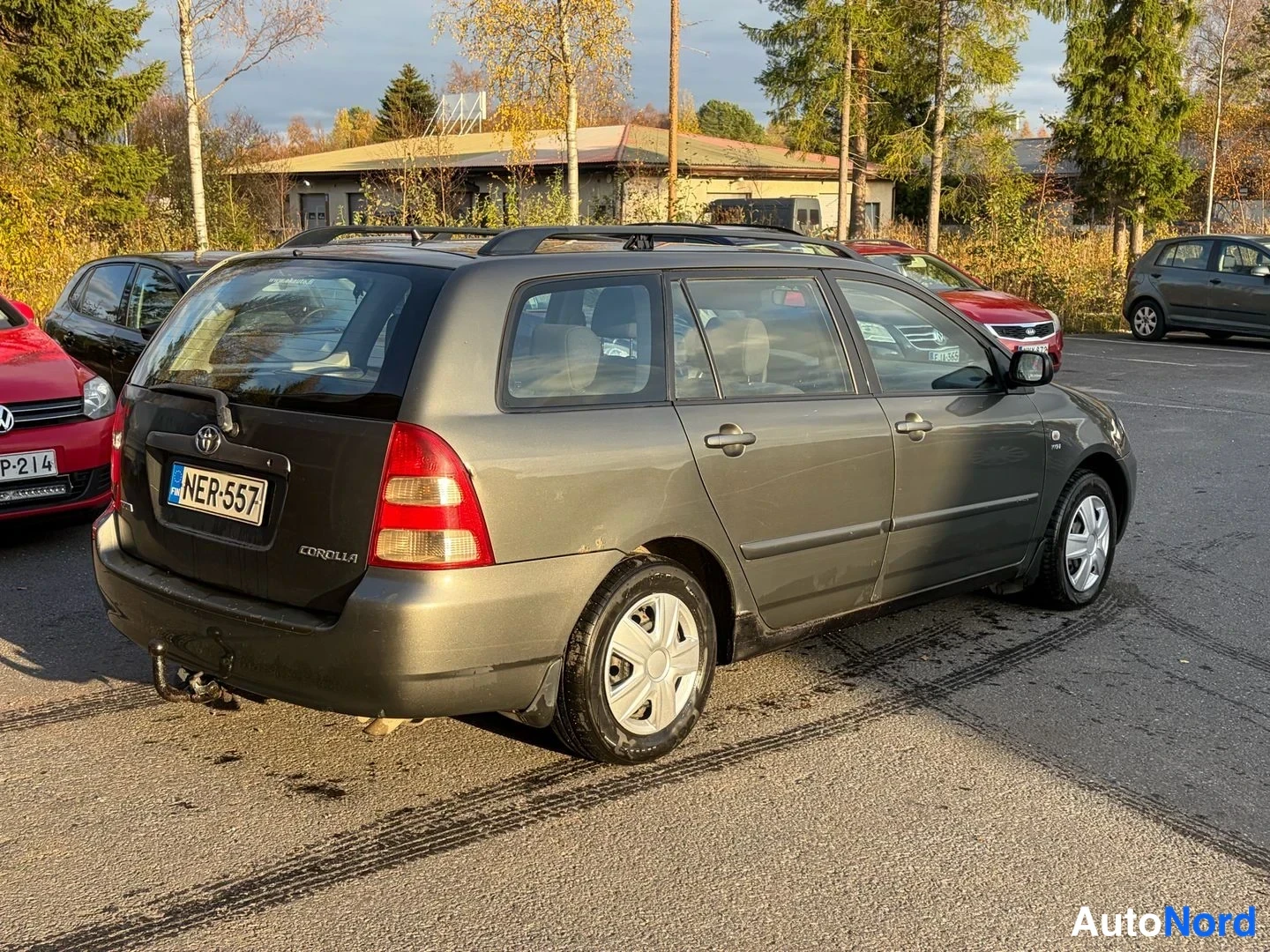 Takaviisto: Tummanharmaa Toyota Corolla -farmari takaa vasemmalta kolmannelta kuvattuna; takavalot, Corolla-teksti ja kylki näkyvät, EU-merkintä.