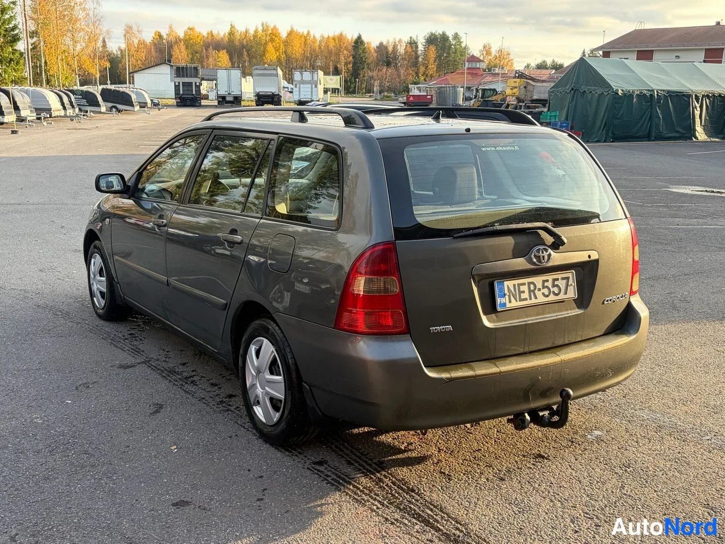 Takaviisto: Tummanharmaa Toyota Corolla -farmari takaa oikealta kolmannelta kuvattuna; takavalot, Toyota-merkki ja kylki näkyvät, EU-merkintä.
