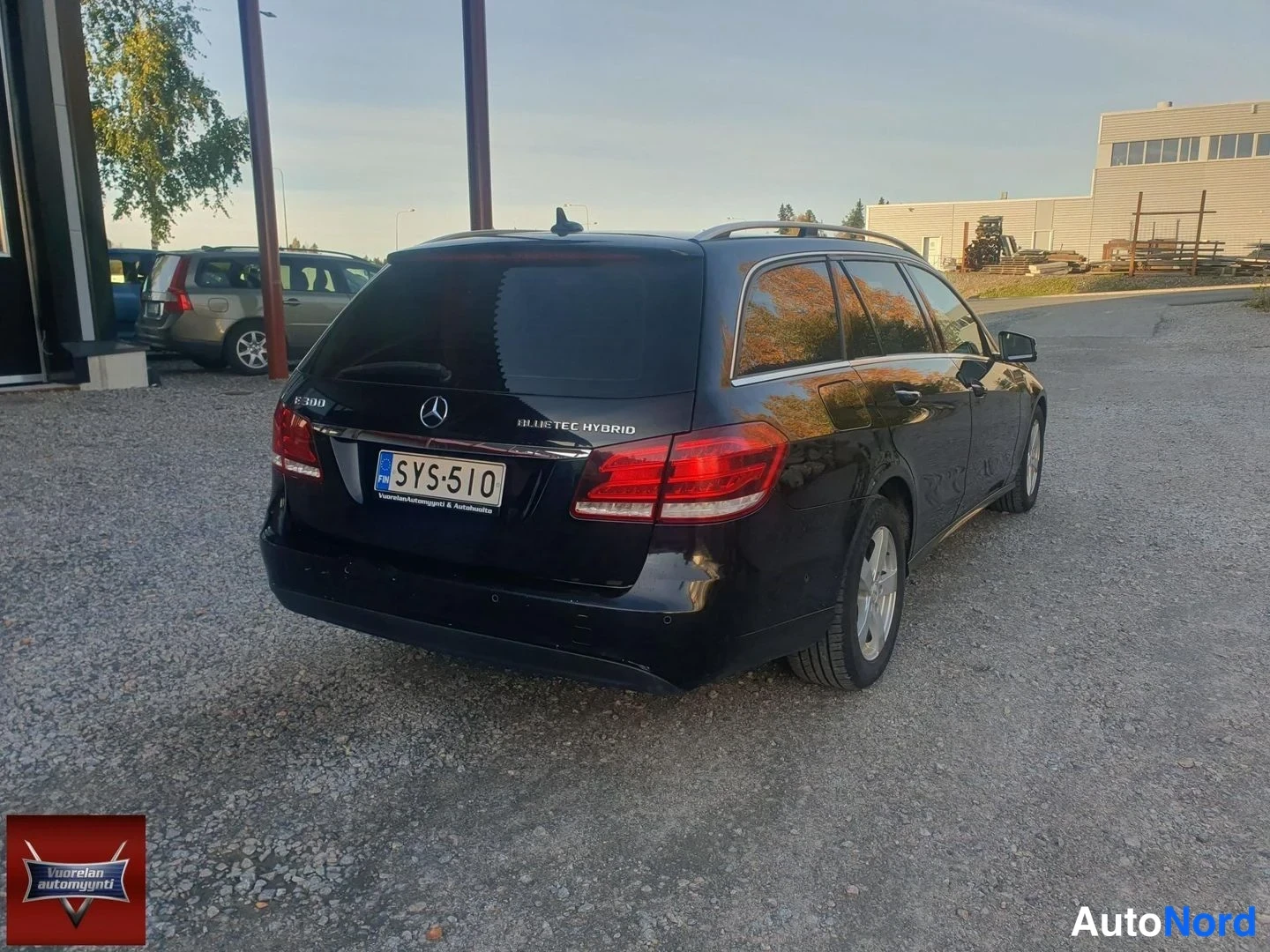 Takaviisto: Musta Mercedes-Benz E 300 BlueTec Hybrid -farmari taka-kulmanurkasta, rekisterikilpi '', merkintä 'BLUE TEC HYBRID' konepellissä.