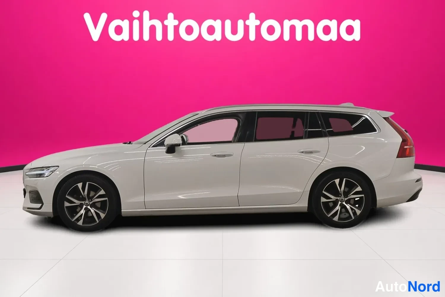 Sivulta: Volvo V60 -farmariauto kokonaan sivulta vasemmalta katsottuna, valkoinen koriväri ja kattokaari näkyvissä