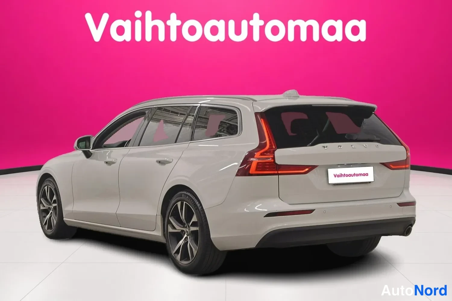 Takaviisto: Valkoinen farmariauto takaa-vinosta kuvattuna, punaiset takavalot ja tummat vanteet.
