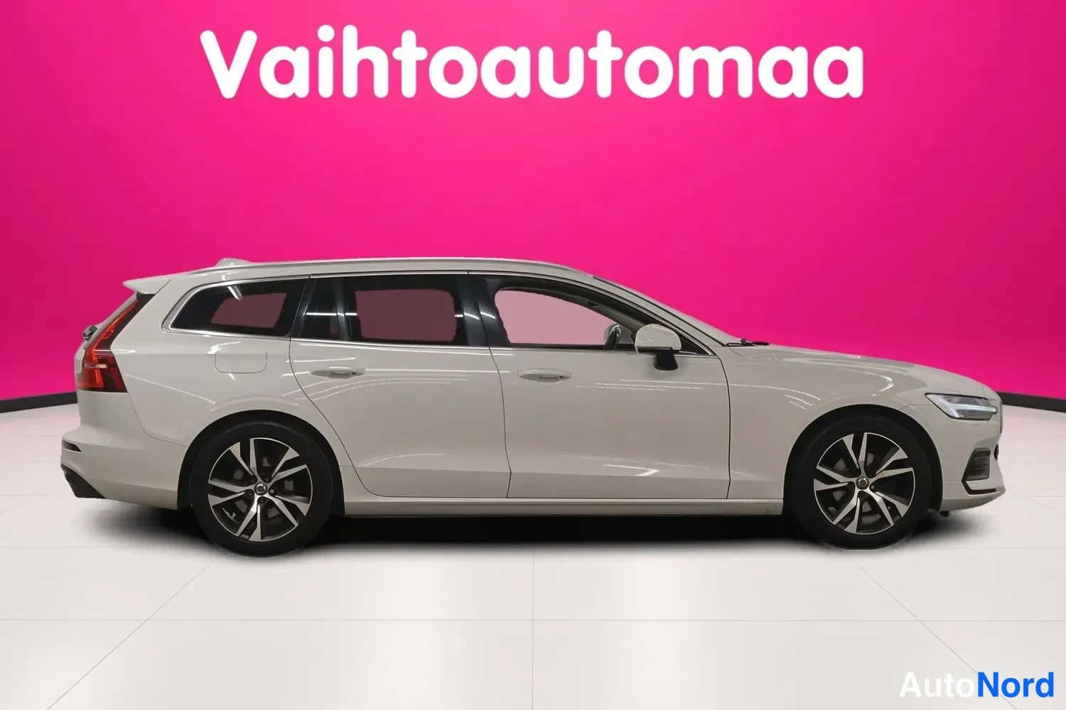 Etuviisto, nokka oikealle: Valkoinen farmariauto vinosti etuviistosta kuvattuna, keula oikealla ja kylki sivusta näkyvissä.