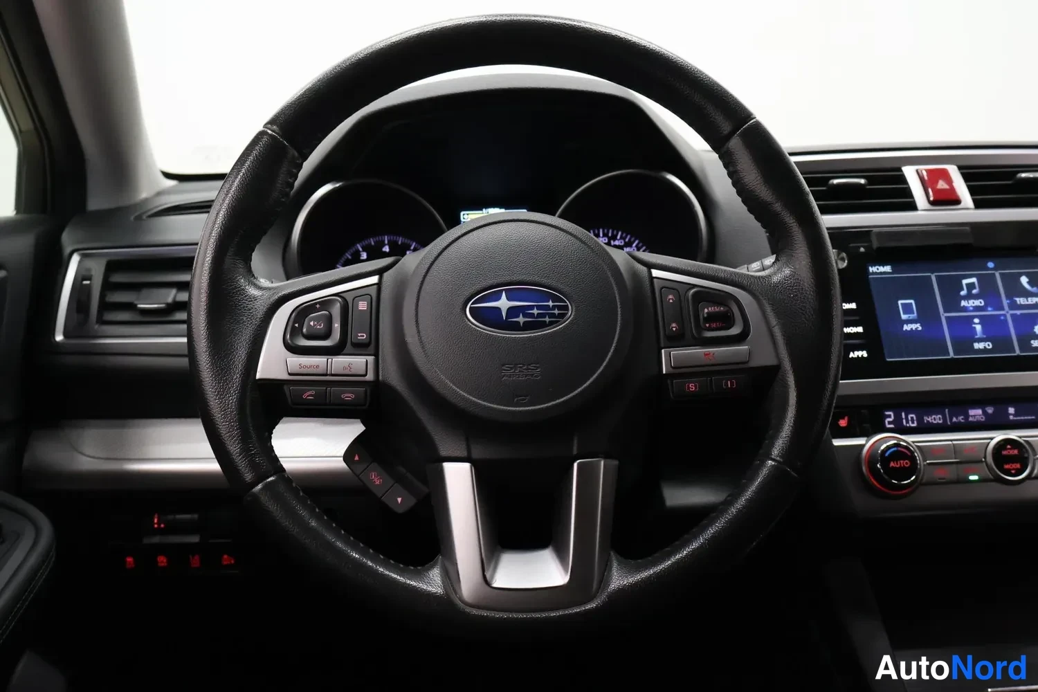 Muu: Ohjauspyörän tarkempi kuva Subaru-merkillä ja kojelaudan infotainment-näytöllä.