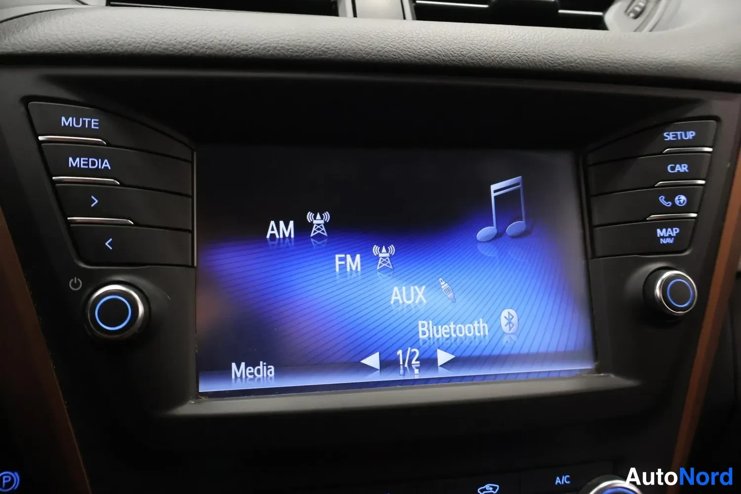 Yksityiskohta: Kohtelaudan viihdejärjestelmän näyttö, jossa valittavana AM, FM, AUX ja Bluetooth, sivuilla MUTE-, MEDIA-, SETUP-, CAR- ja MAP NAV -painikkeet.