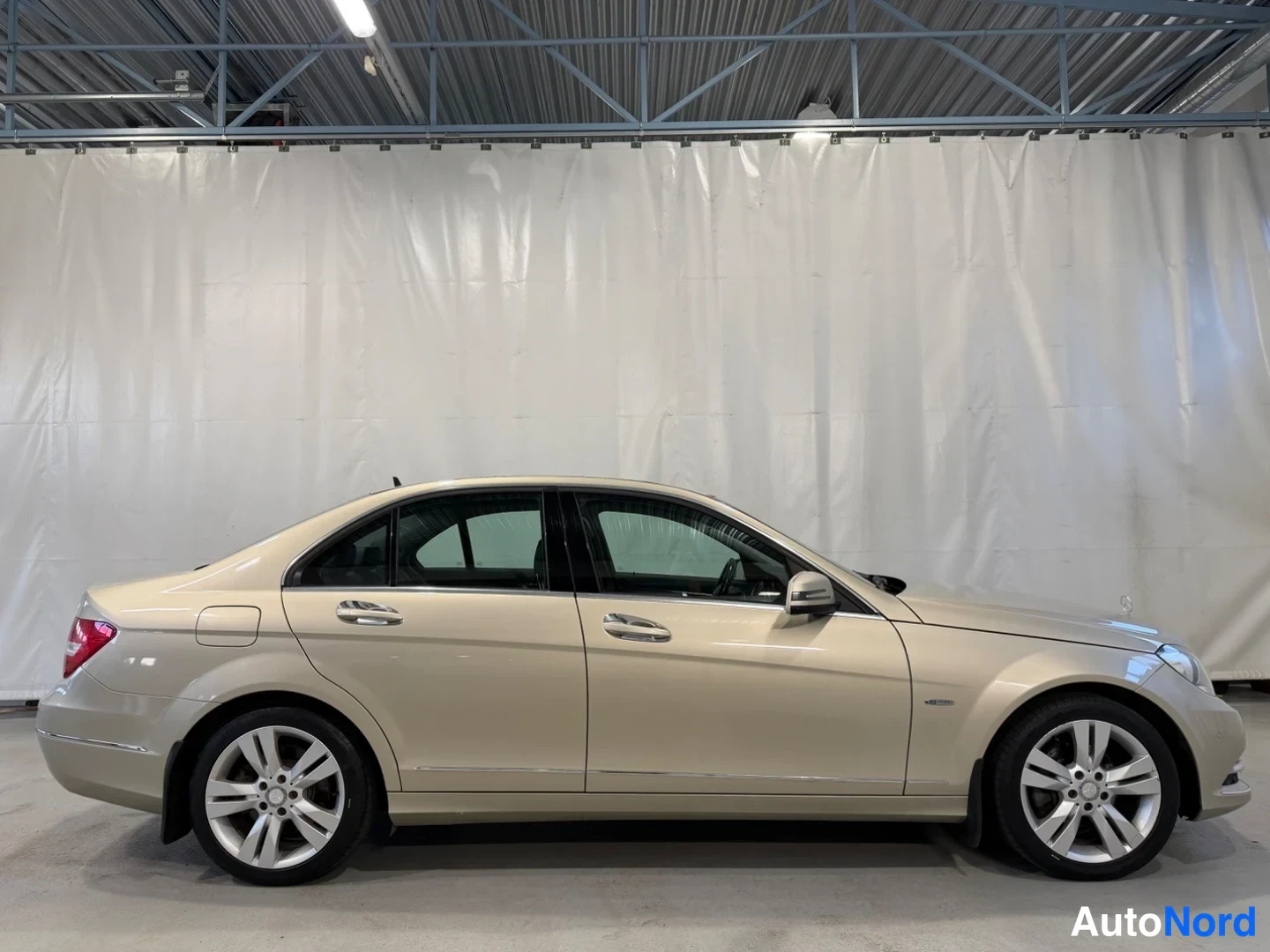 Takaviisto: Mercedes-Benz C-sedan sivukuva oikealta, beige väri, alumiinivanteet.