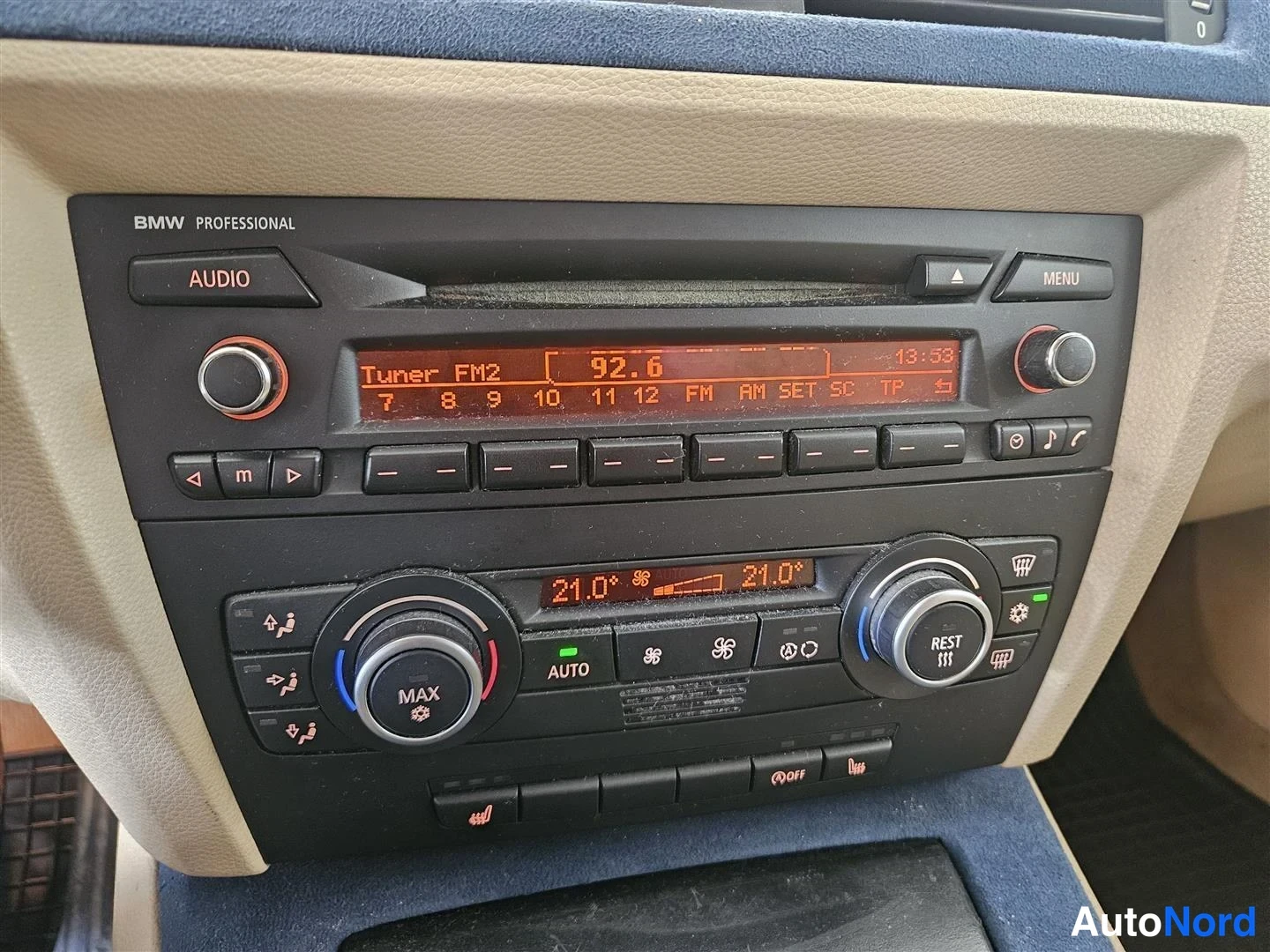 Yksityiskohta: Kojelaudan keskusyksikkö: BMW Professional -radio näyttää Tuner FM2 92.6, alla kaksialueinen ilmastointi asetuksin 21,0°.