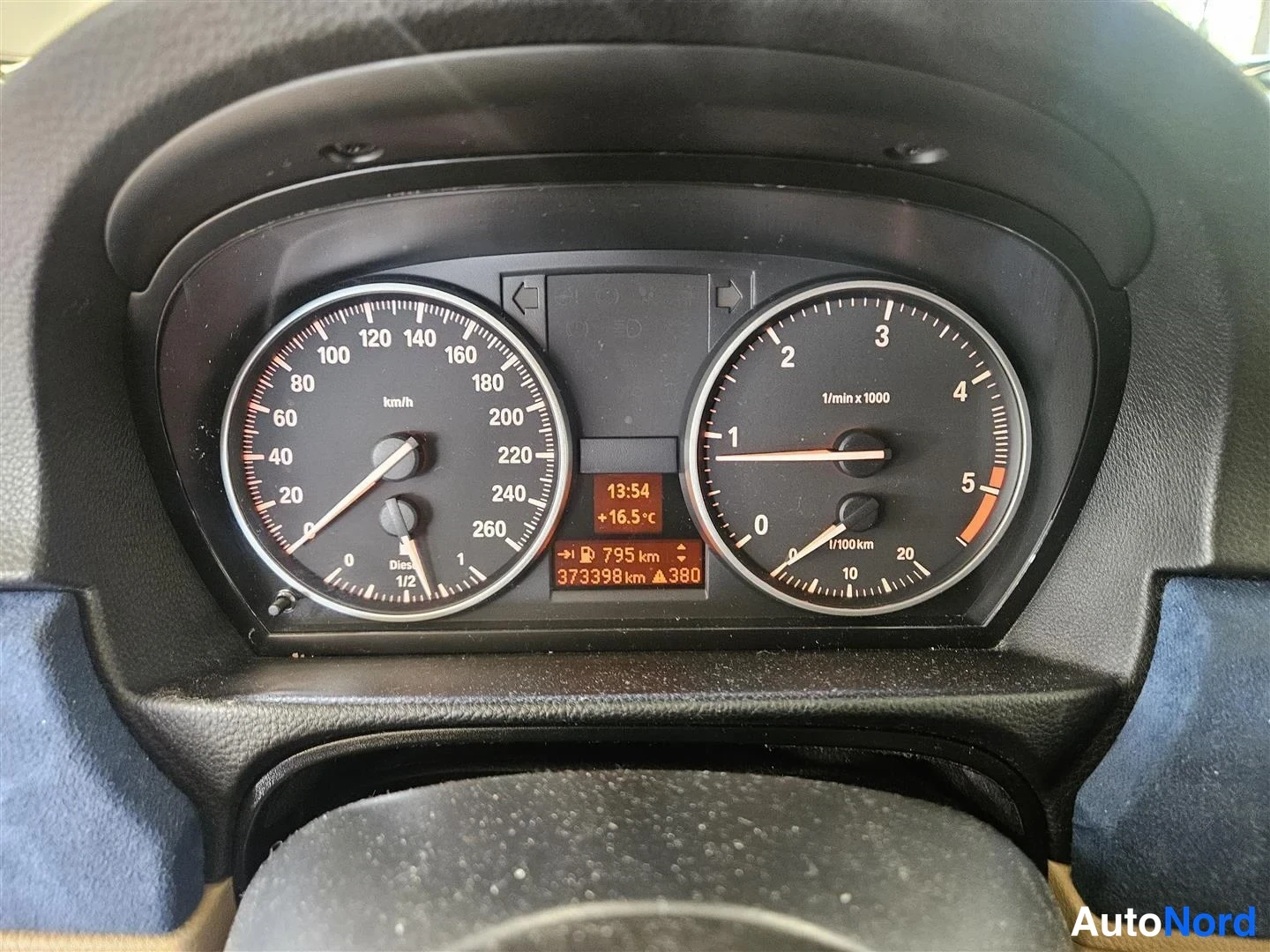 Yksityiskohta: BMW:n mittaristo: nopeusmittari, kierrosmittari ja näyttö, jossa lukee 373398 km.
