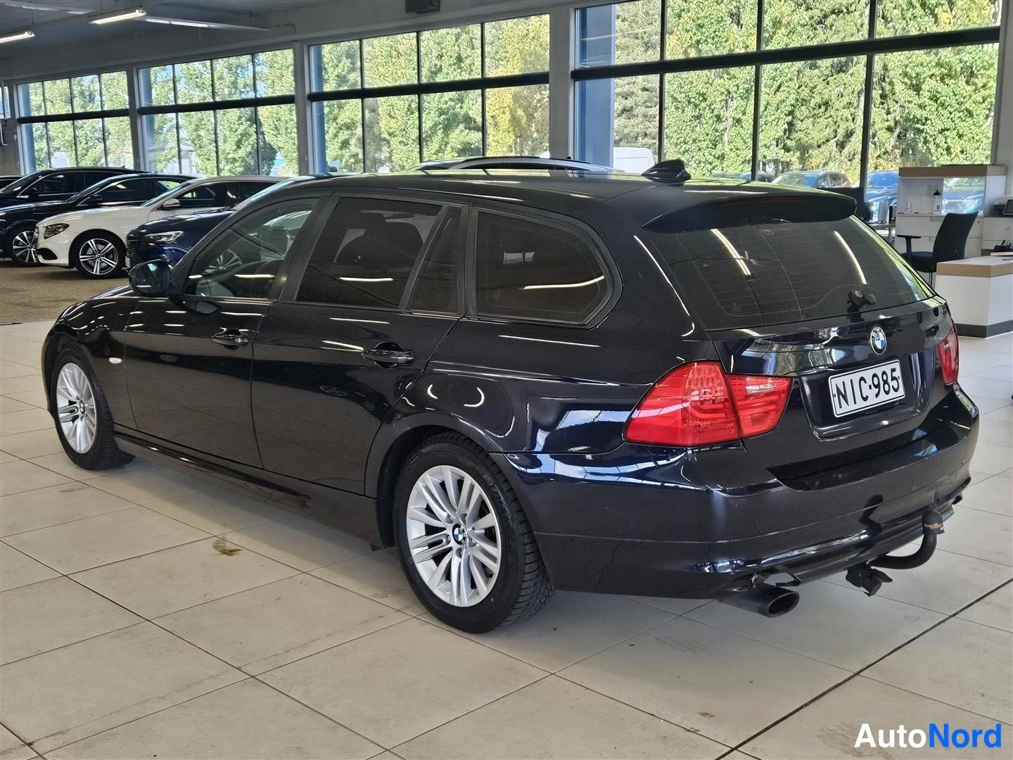 Takaviisto: Tumma BMW-farmari takaviistosta, rekisteritunnus, vetokoulu ja kaksoipakoputki näkyvissä.