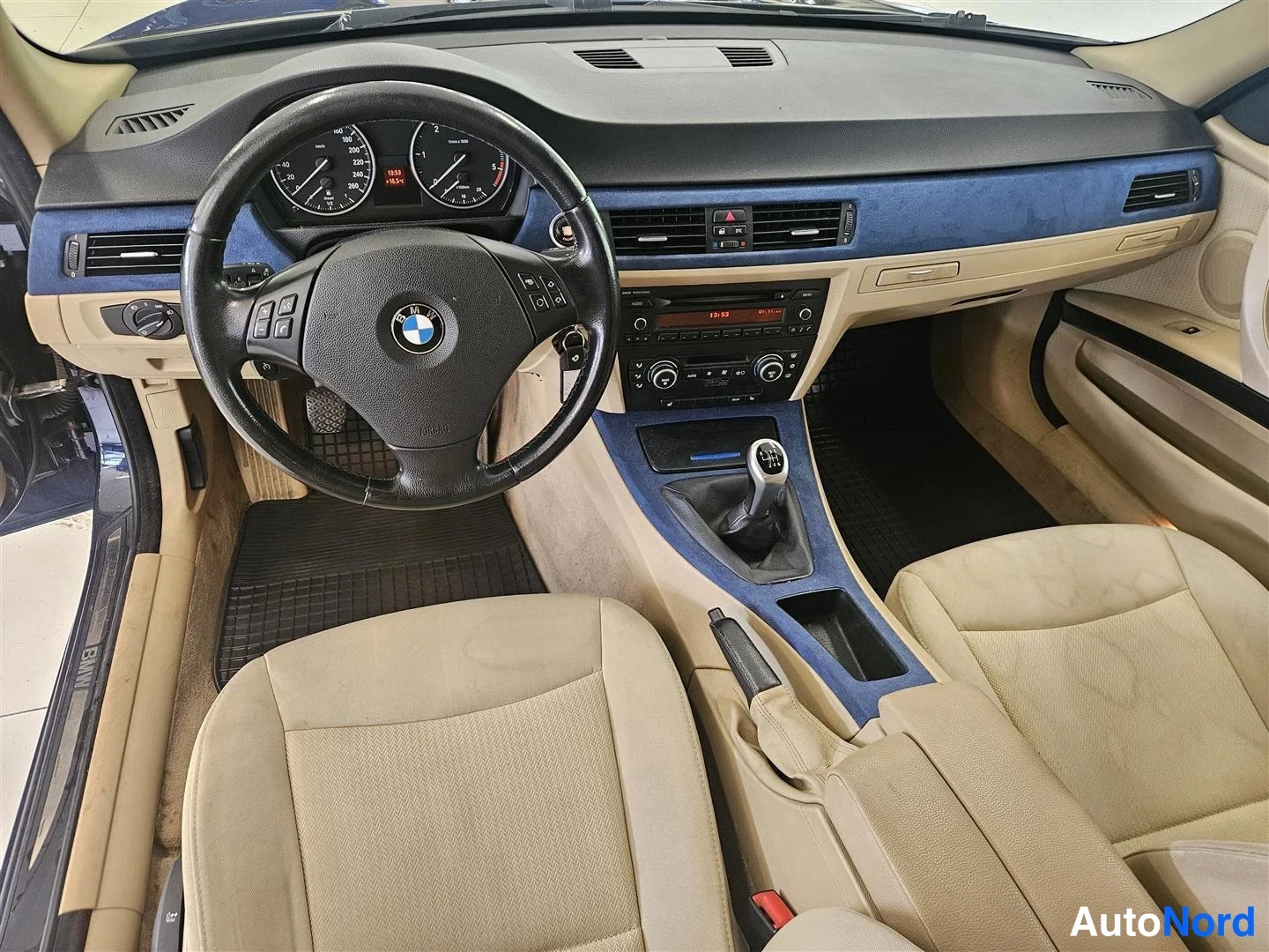 Muu: Ohjaamo vasemmalta: BMW-ohjauspyörä, analogiset mittarit, manuaalivaihtopoljin, radio/konsolipaneeli ja kaksi beigeä istuinta. Kojelaudan koristeosat siniset.