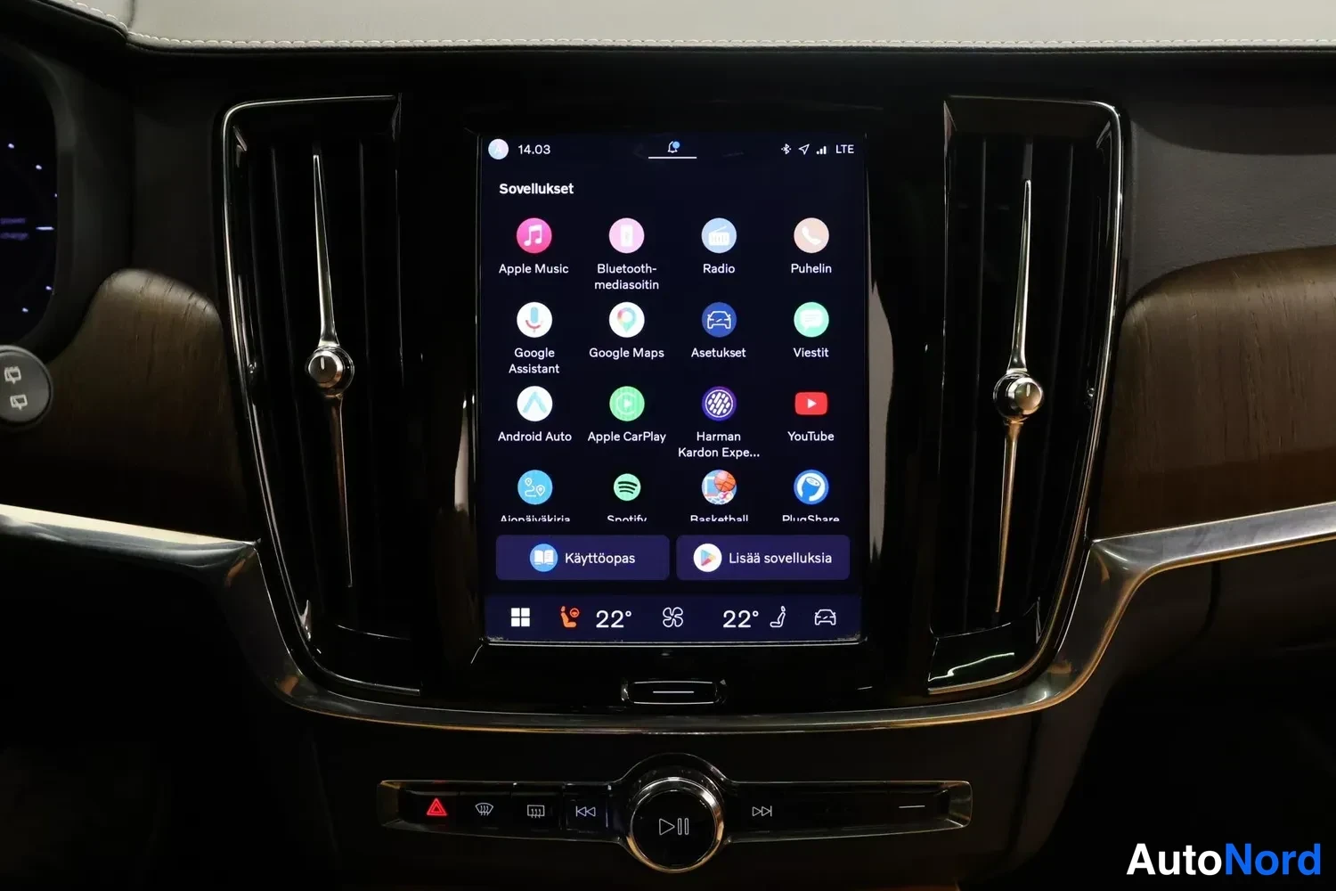 Yksityiskohta: Kojelaudan infotainment-näyttö, jossa näkyy sovellusvalikko (mm. Apple Music, Spotify, Google Maps, Apple CarPlay, Android Auto) ja ilmastoinnin lämpötilat 22 a