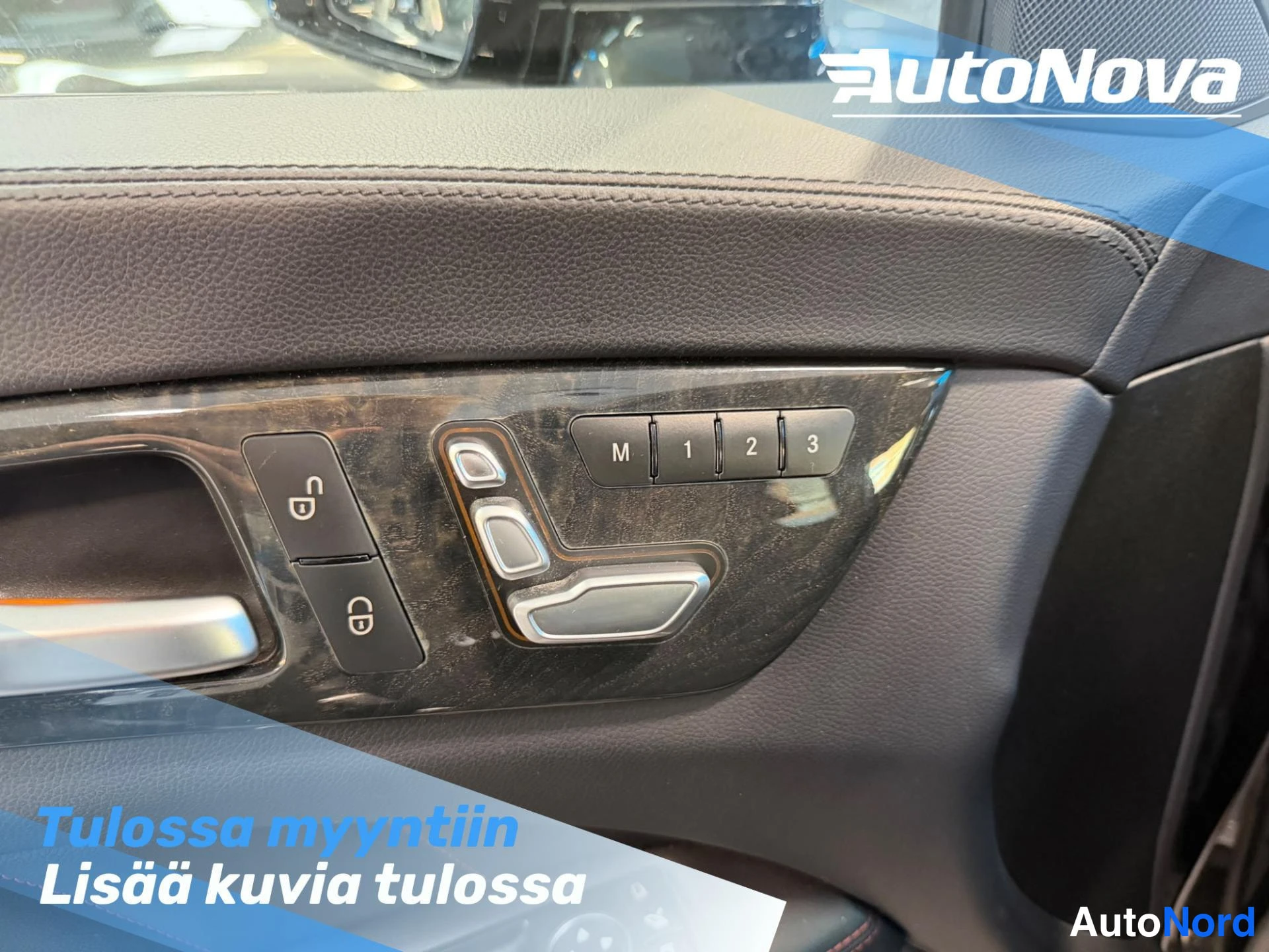 Muu: Auton oven sisäpaneelin lähikuva: keskuslukituksen lukitus- ja avausnapit, istuinmuistipainikkeet M, 1, 2, 3 ja istuimen säätönappulat tummassa ovipaneelissa.