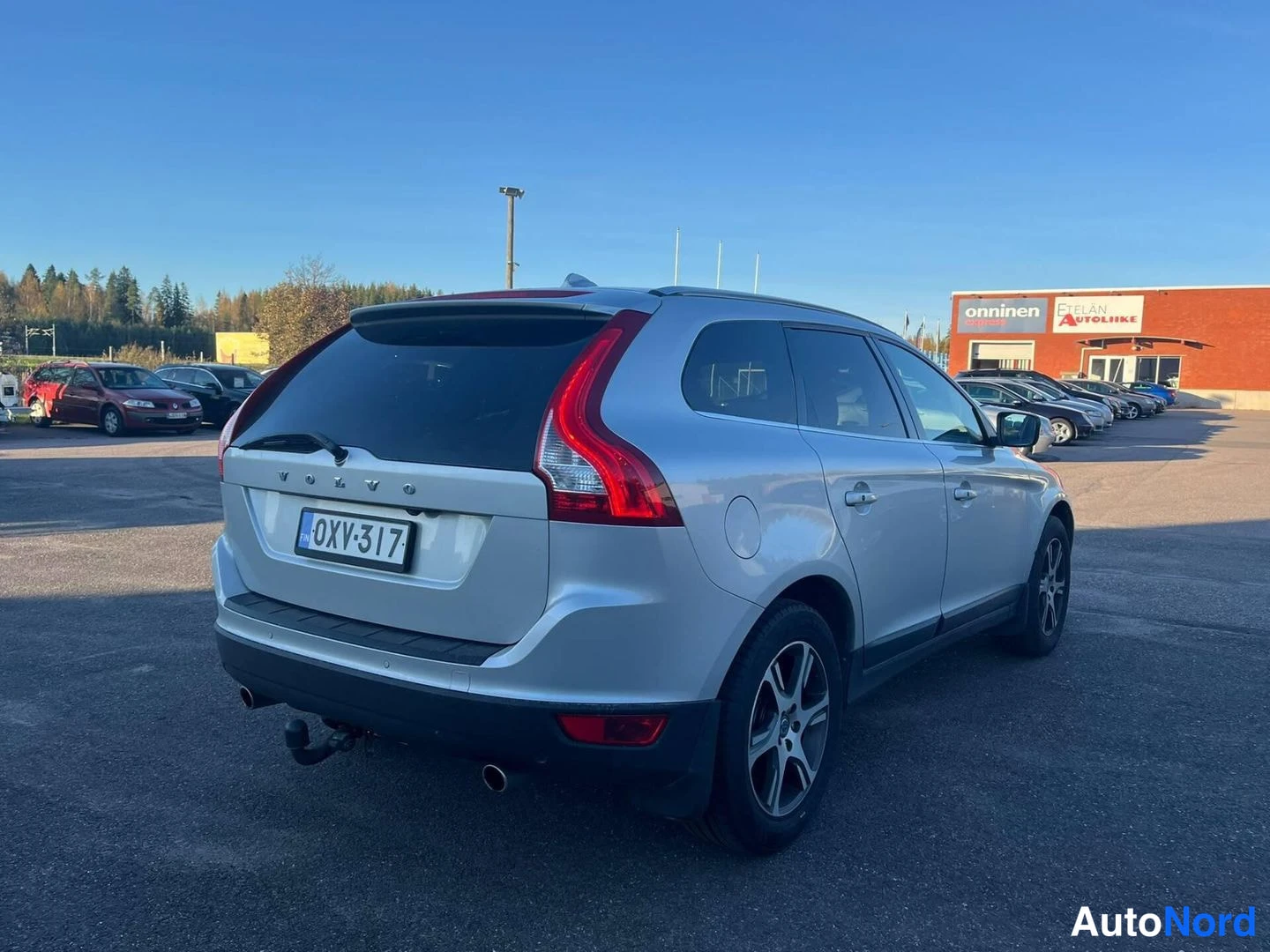 Takaviisto: Hopeanvärinen Volvo XC60:n takakulma, rekisterikilpi, takavalot ja perävaunukoukku näkyvissä.
