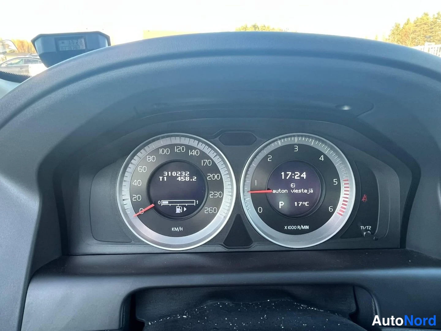 Muu: Mittaristön lähikuva: nopeusmittari 0–260 km/h ja kierrosmittari, näytössä lukemat 310232 km ja 458.2, kello 17:24, lämpötila 17 °C ja vaihde P.