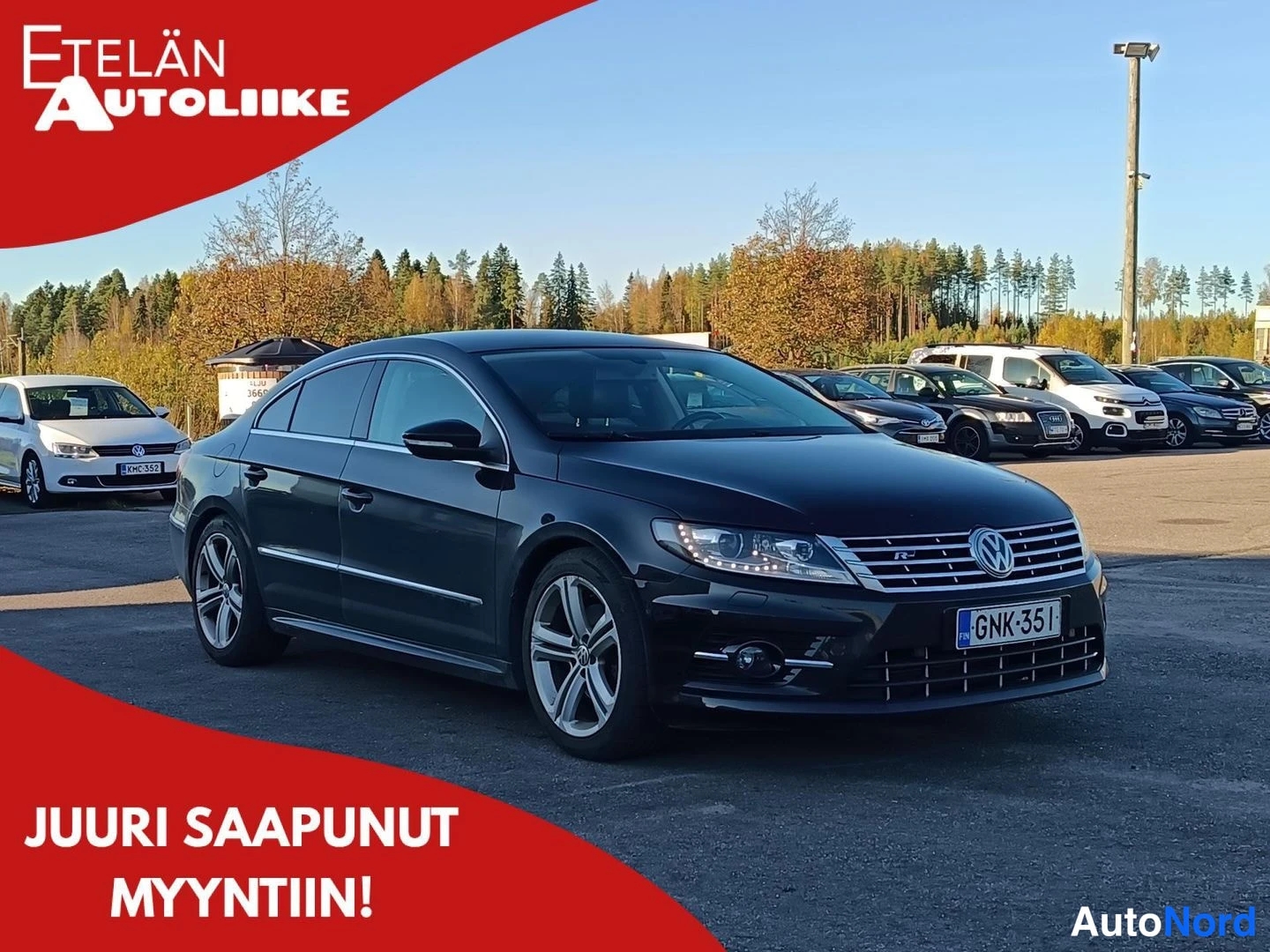Etuviisto, nokka oikealle: Mustan Volkswagen CC:n etukulma näkyy etualalla, etupyörä ja kylki vasemmalla, rekisterikilpi.