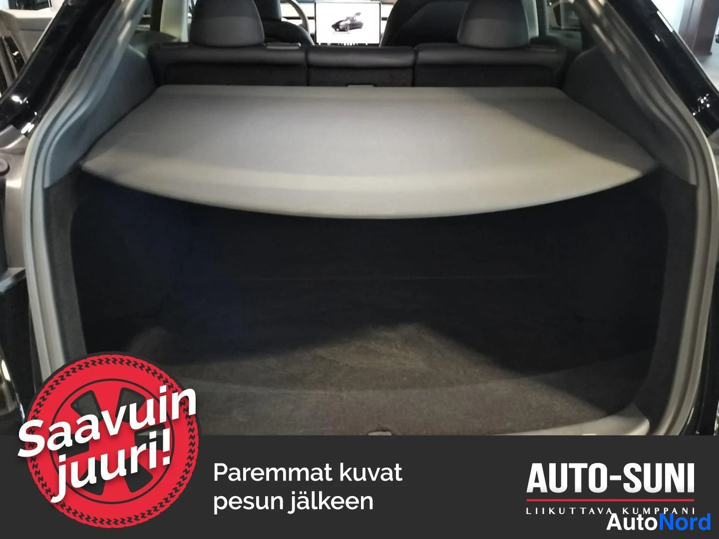 Muu: Auton tavaratila, jonka päällä on asennettu säilytystaso/konetaivi, taustalla taitettuna tavaratilan suojaverho