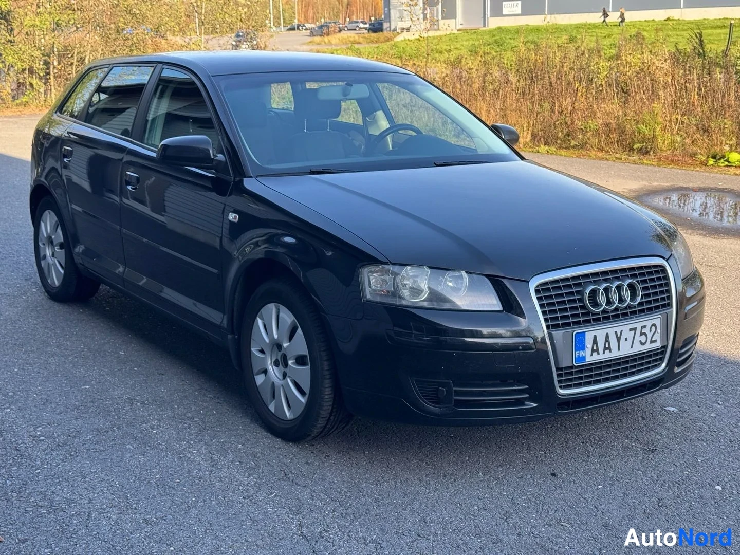 Etuviisto, nokka oikealle: Musta Audi A3 viistoperä edestä toiselta sivulta, rekisteritunnus.