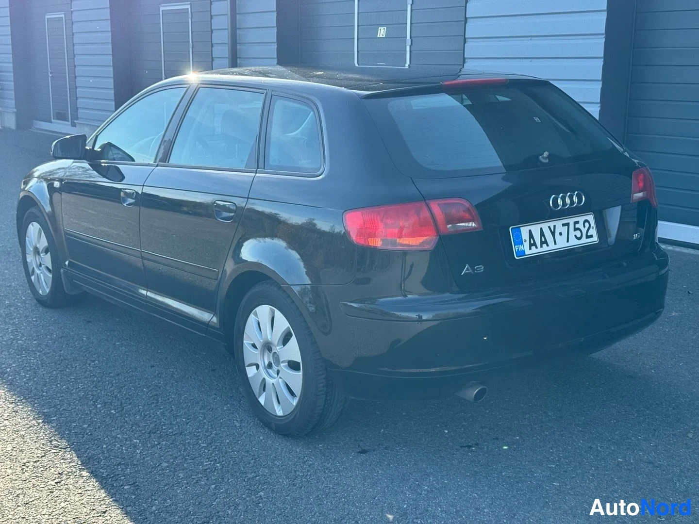 Takaviisto: Mustan viistoperäisen auton takakolmasosan näkymä vasemmalta, rekisterikilpi ja Audi-merkki näkyvät.