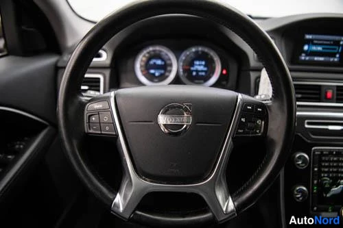 Muu: Volvo-ohjauspyörä ja kojelauan mittarit sisäkuvaasta.