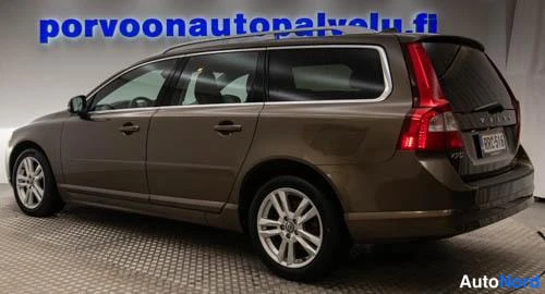 Takaviisto: Ruskea Volvo V70 -farmari takaviistosta vasemmalta nähtynä sisätiloissa, rekisteritunnus.