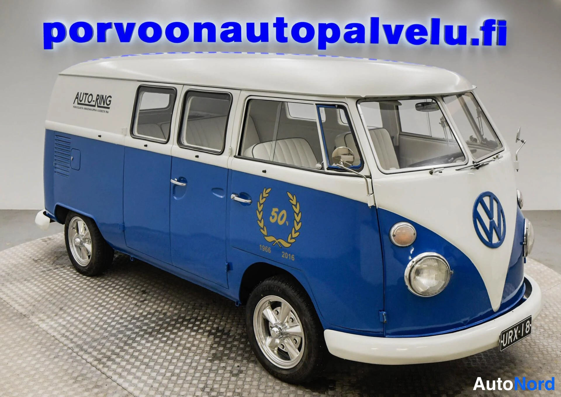 Etuviisto, nokka oikealle: Pakettiauton etukulma oikealta: pyöreät ajovalot, VW-merkki konepellin V-osassa ja rekisteritunnus.