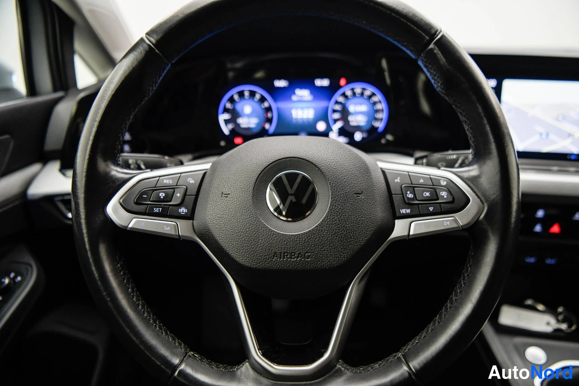 Yksityiskohta: Volkswagenin ohjauspyörä ja digitaalinen mittaristö sisätiloissa.