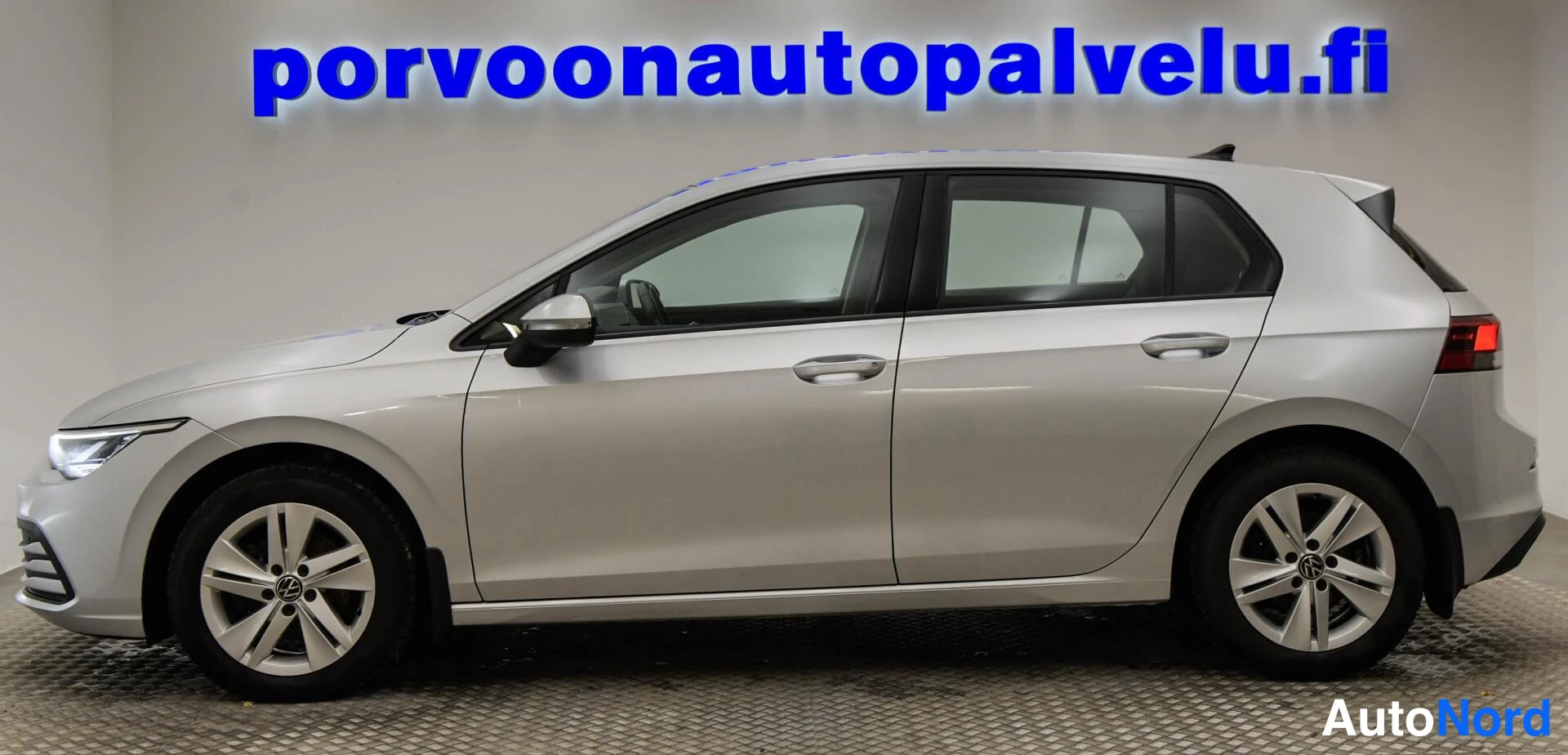Etuviisto, nokka vasemmalle: Volkswagen Golf -henkilöauto sivulta vasemmalta, hopeanvärinen kori.
