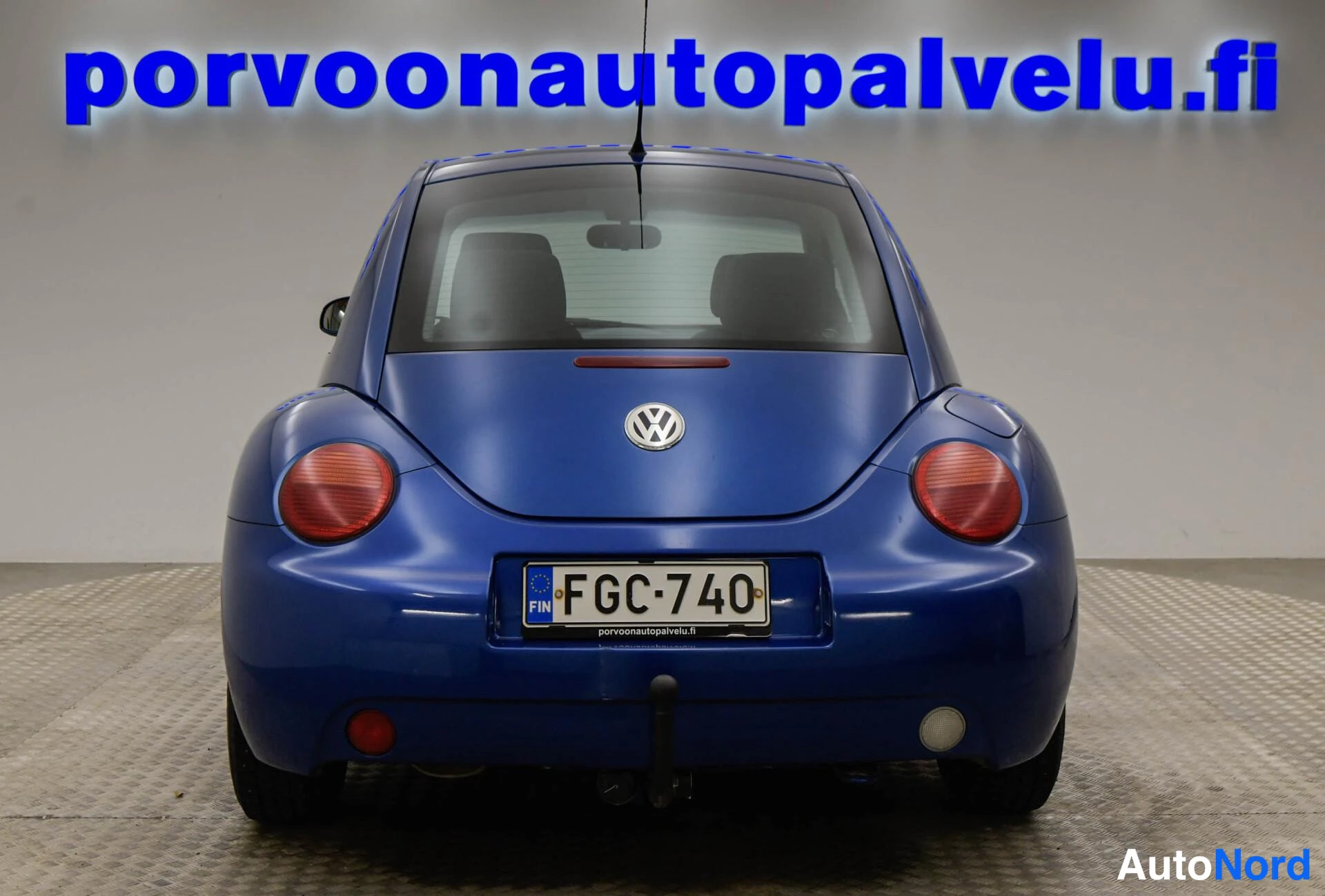 Takaa: Sininen Volkswagen New Beetle suora takaapäin, rekisterikilpi.