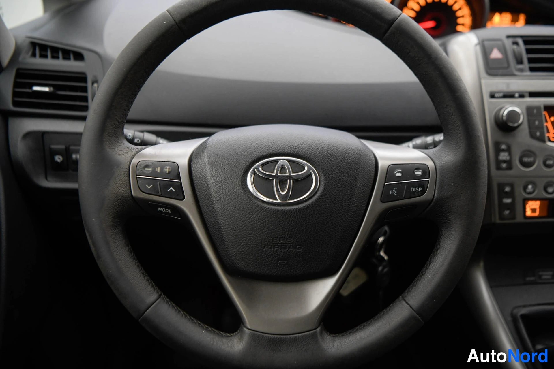 Sivulta: Lähikuva Toyotan ohjauspyörästä, jossa on äänentojätö- ja DISD-nappulat sekä SRS Airbag -merkintä.