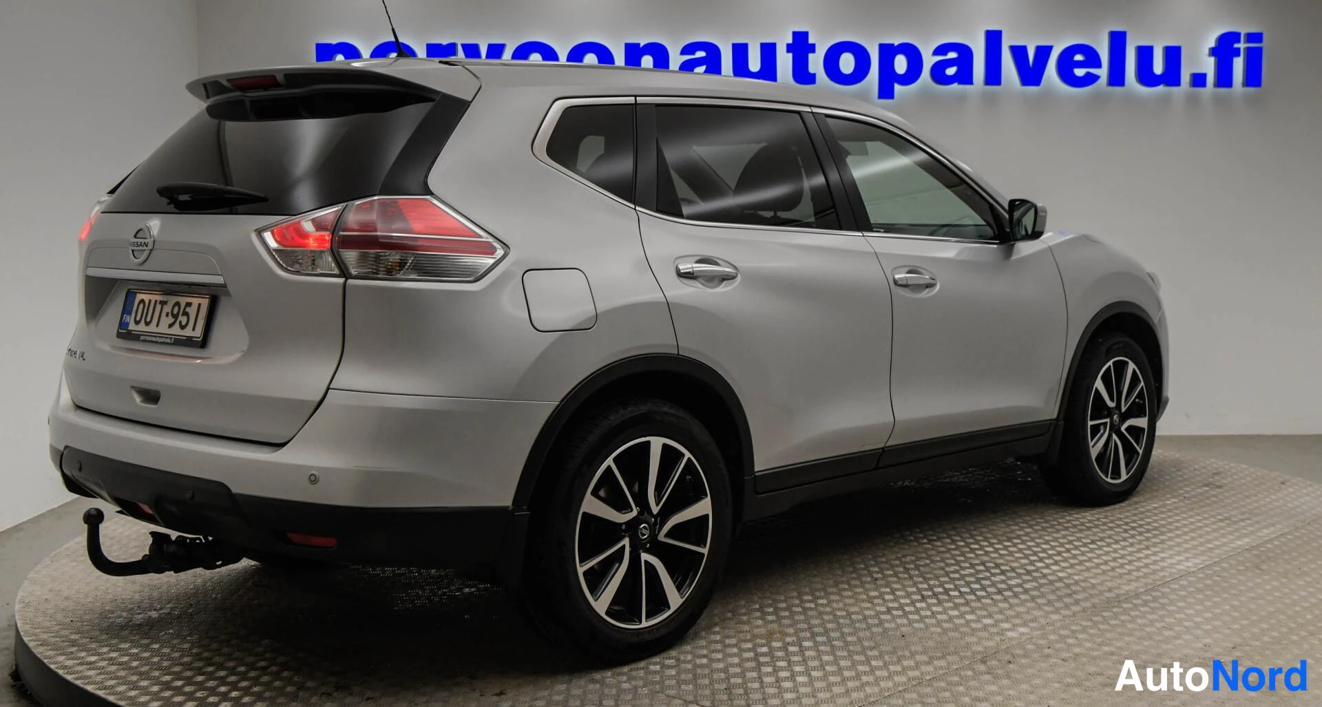 Takaviisto: Hopeanvärinen Nissan X-Trail takaa oikealta kulmakuvana, rekisteritunnus.