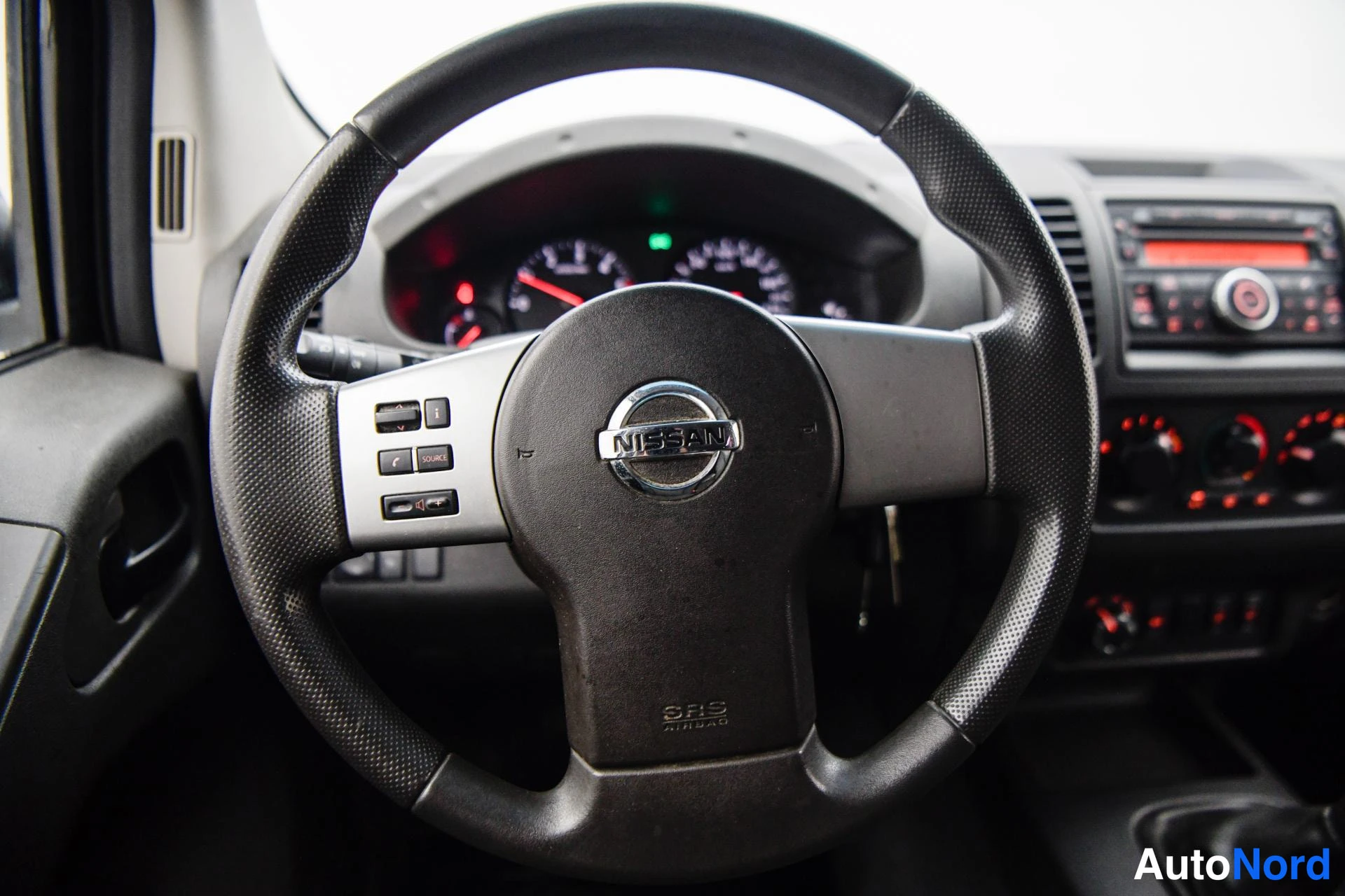 Muu: Ohjauspyörän lähikuva, Nissan-merkki ja SRS airbag -teksti näkyvissä.
