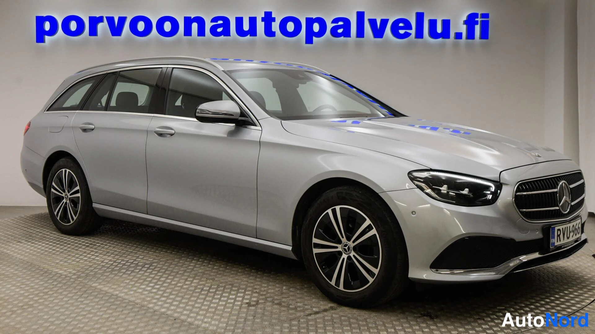 Etuviisto, nokka oikealle: Mercedes-Benz E-sarjan farmari etuviistosta oikealta, hopeametallinen kori, LED-ajovalot ja Mercedes-tähti etusäleikössä, rekisterikilpi.