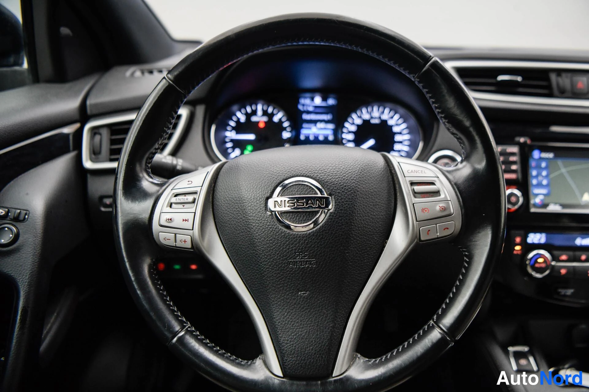 Muu: Nissan-merkillinen ohjauspyörä ja kojelautamittarit sisäkuvassa.