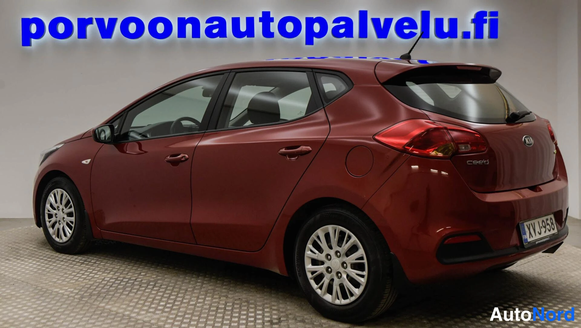 Takaviisto: Punainen Kia cee'd -viistoperäauto takaviistosta kuvattuna, takavalot ja korin vasen sivu näkyvissä.