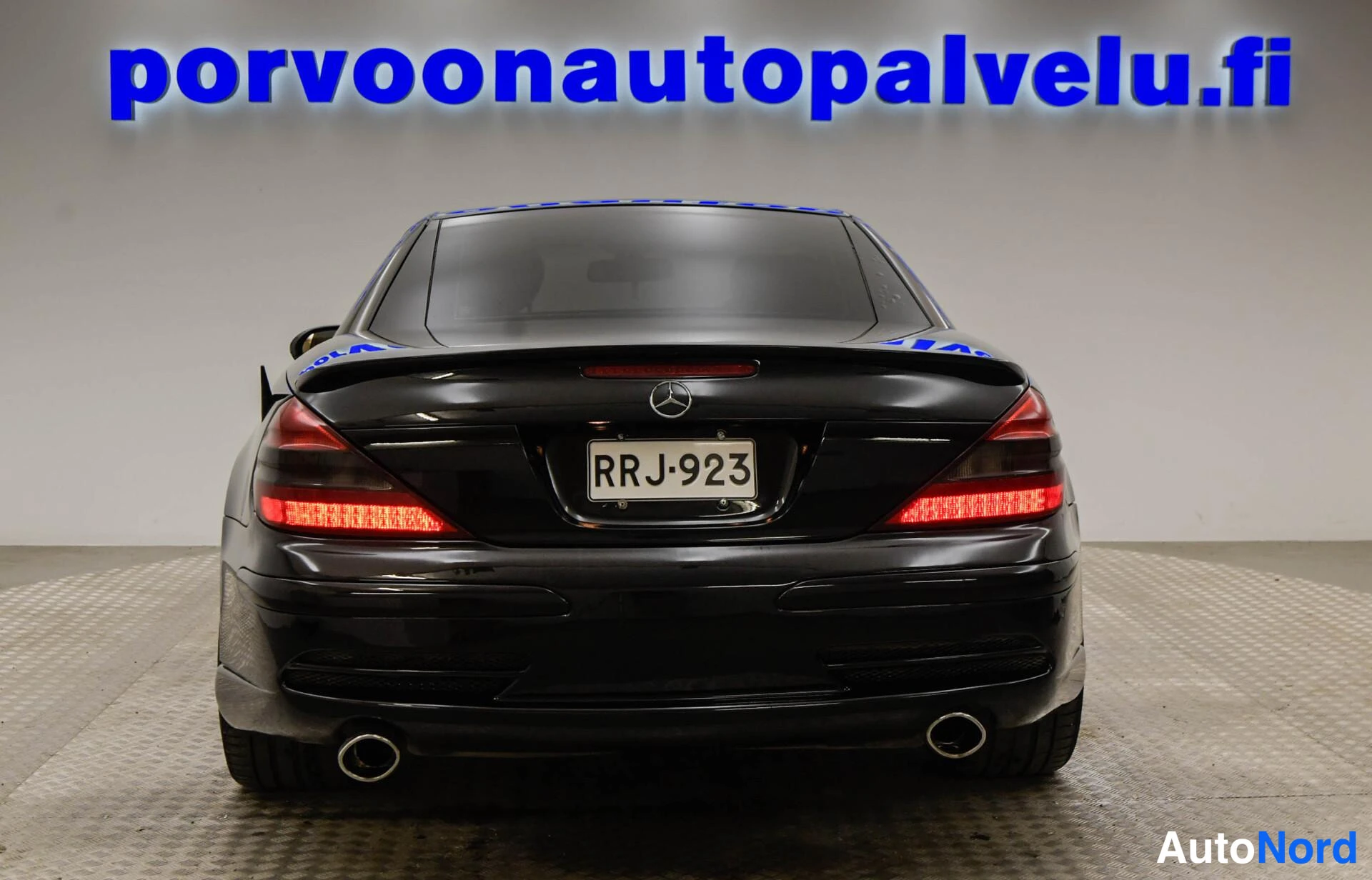 Takaa: Mustan Mercedes-Benz SL -auton takanäkymä, rekisteritunnus ja kaksi pakoputkea.