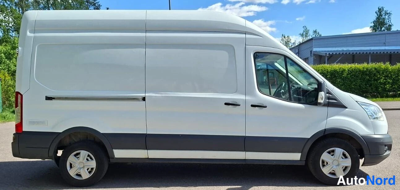 Etuviisto, nokka oikealle: Valkoinen pakettiauto vasemmalta sivulta keulakulmasta kuvattuna