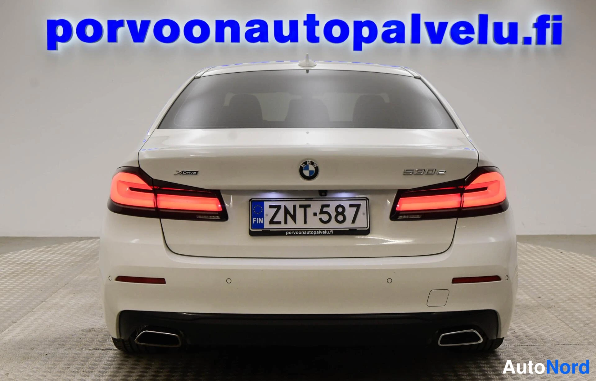 Takaa: Valkoisen BMW-sedan takaosa suoraan takaa, mallimerkintä 530e ja rekisteritunnus.