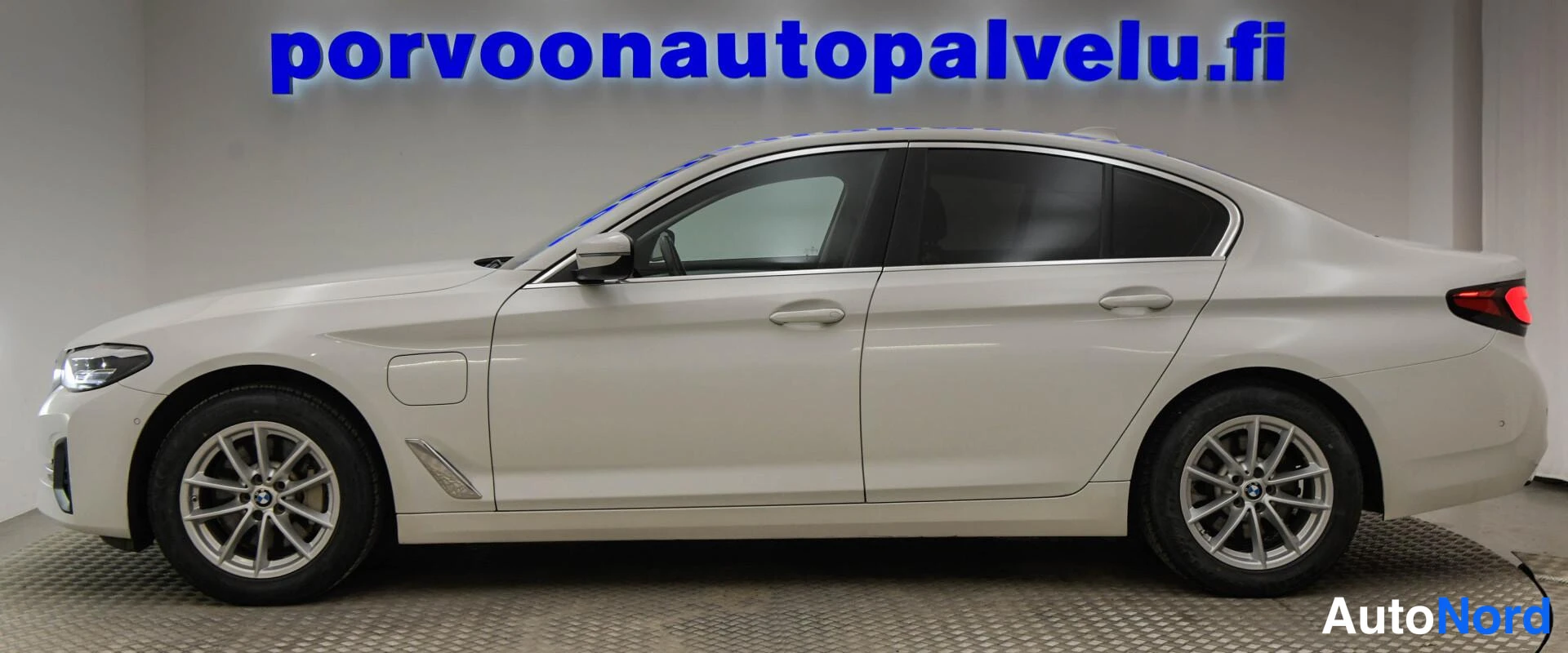 Etuviisto, nokka vasemmalle: Valkoinen BMW-sedan sivuprofiilissa, keulakko vasemmalla.