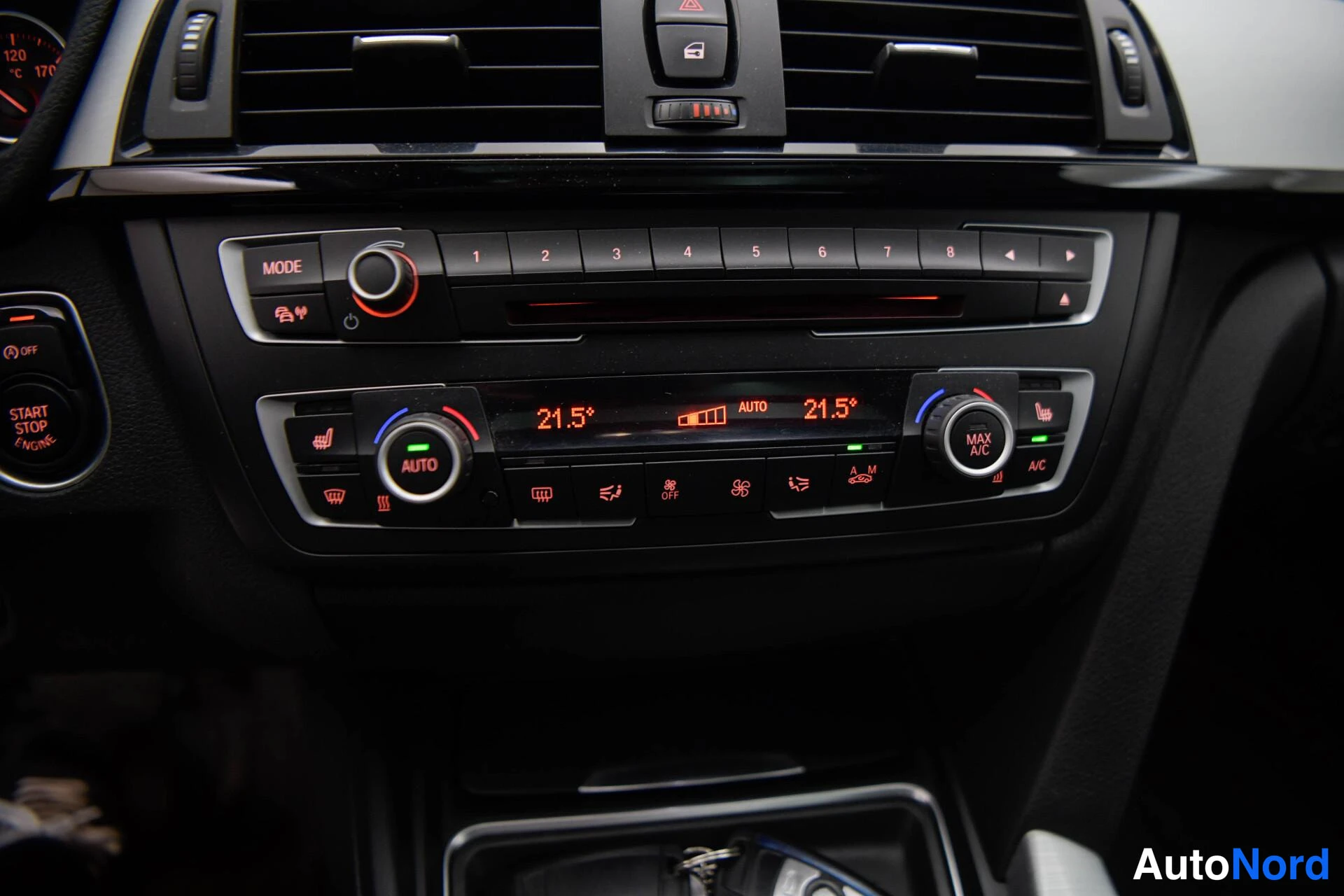 Etuviisto, nokka vasemmalle: Keskikonsolin ilmastointi- ja viihdejärjestelmän säädöt: automaattikaksipaikkainen ilmastointi 21,5 °C, radio- ja nappirivi numeroin 1–8, Start/Stop-pa