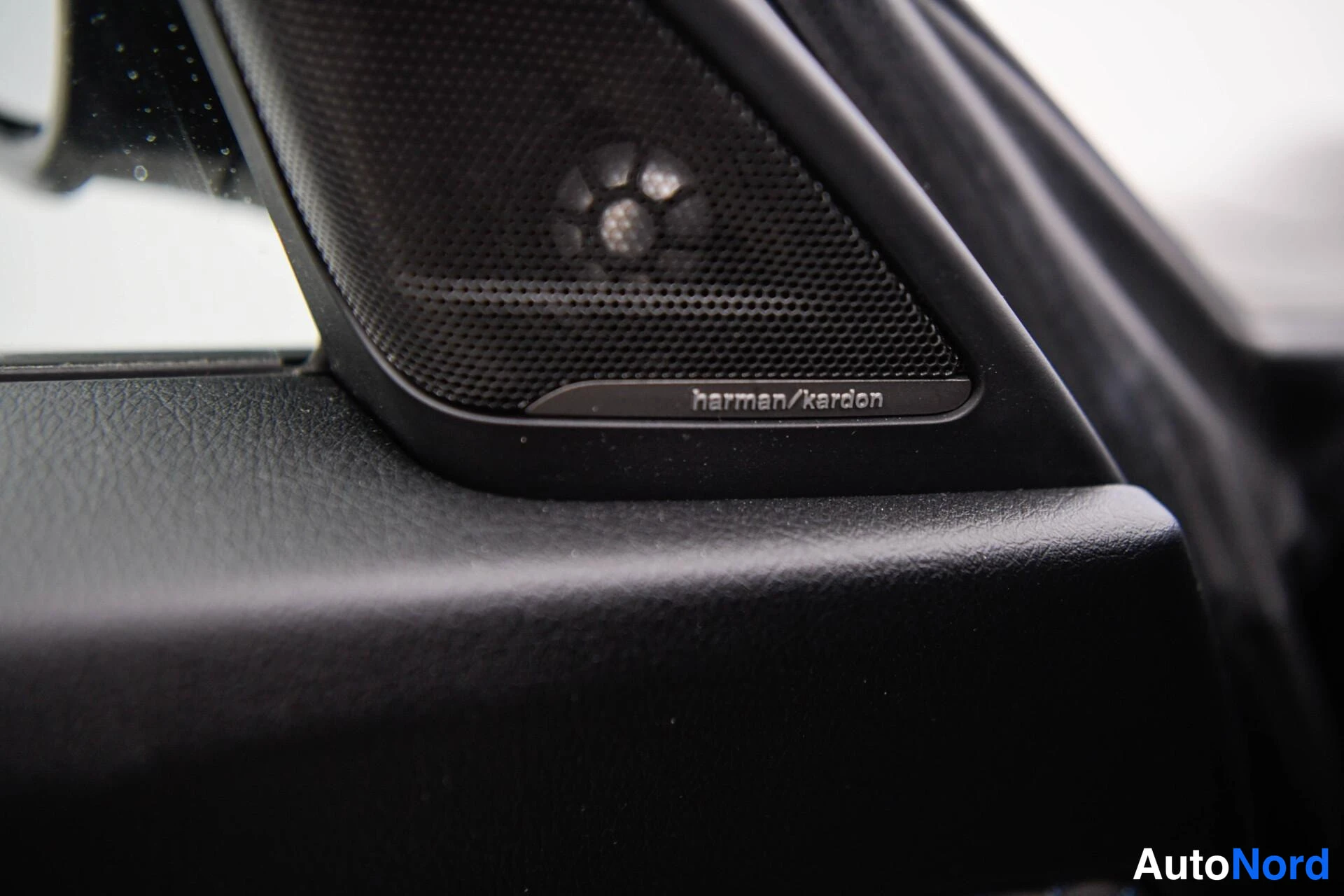 Yksityiskohta: Harman/Kardon -merkkinen kaiutinkotelo auton sisätilassa.
