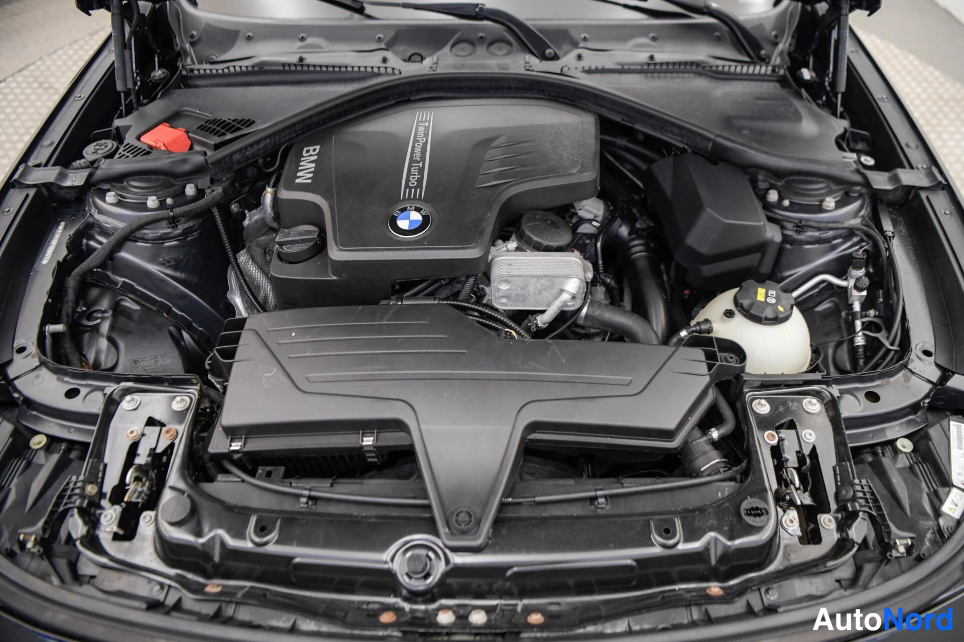 Muu: Avattu moottoritila, BMW TwinPower Turbo -kansi ja valkoinen paisuvasäiliö näkyvissä.