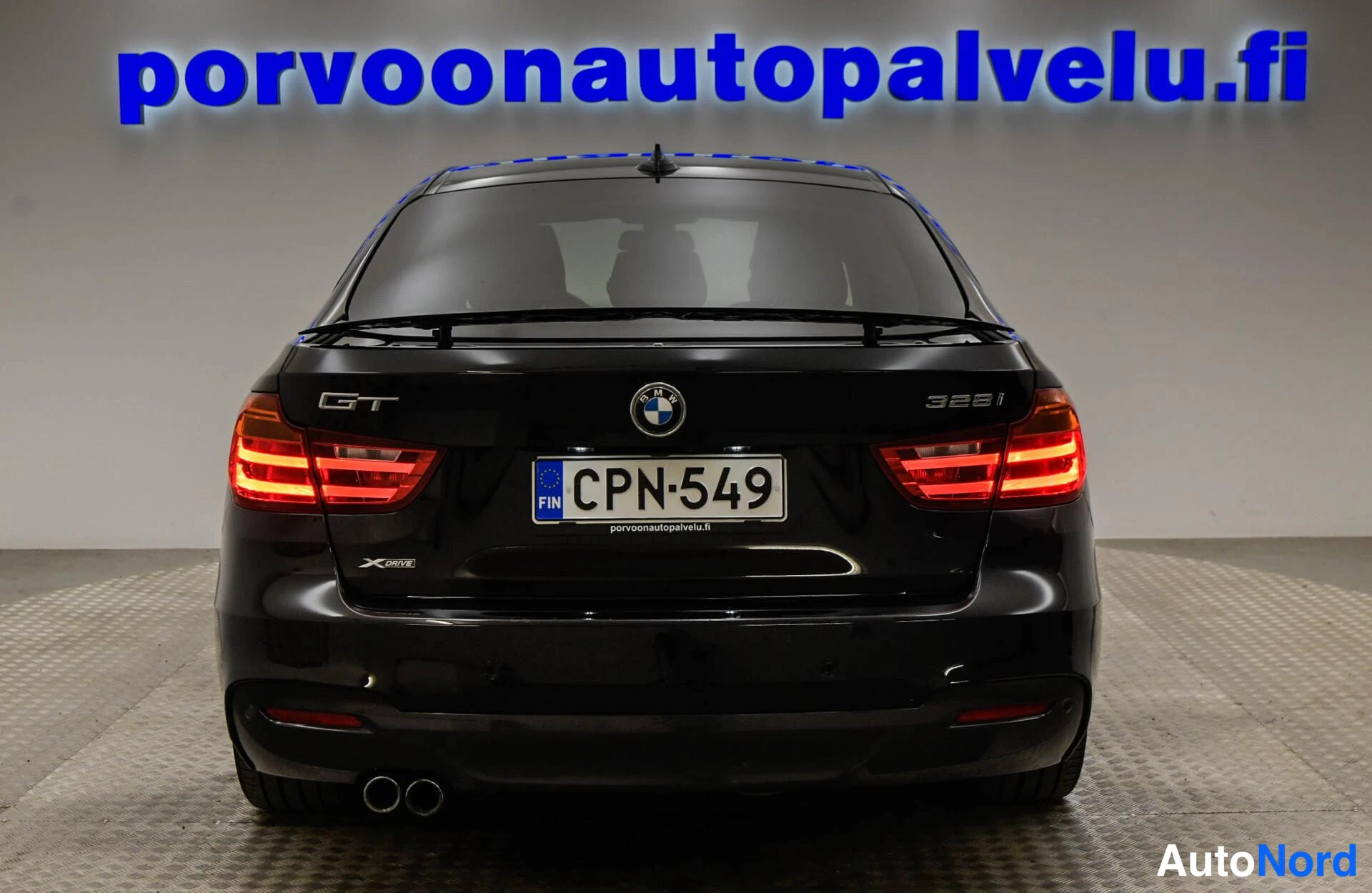 Takaa: Mustan BMW:n takaosa suoraan takaa; GT- ja 328i-merkit, XDrive-merkki ja rekisterikilpi näkyvissä.