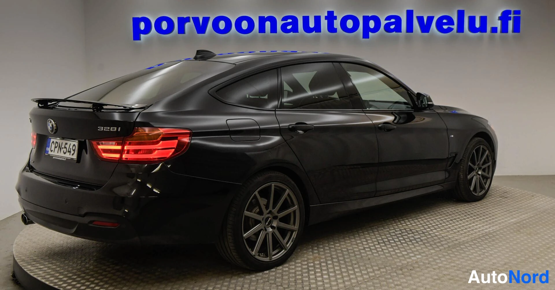 Takaviisto: Musta BMW:n takaosa ja sivuprofiili, rekisteri, takavaloja ja tumble-edustus.
