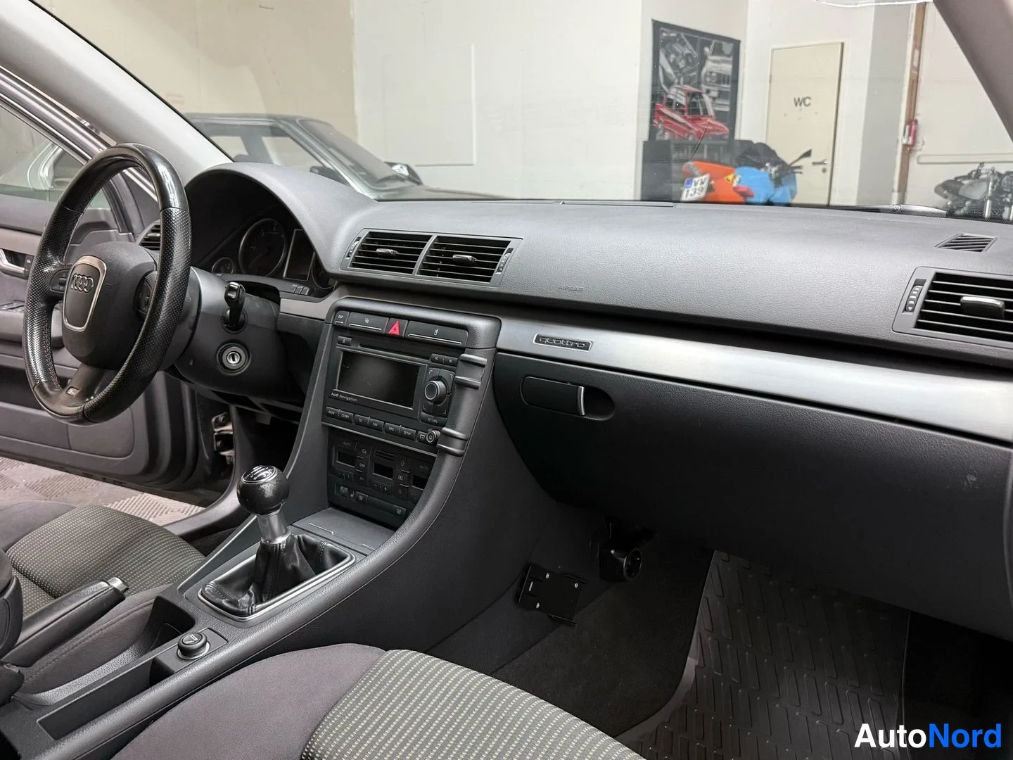 Edestä: Kojelauta vasemmalta: Audi-ohjauspyörä, radio- ja ilmastointipaneeli, käsivalintainen vaihtaja ja tummat matot.